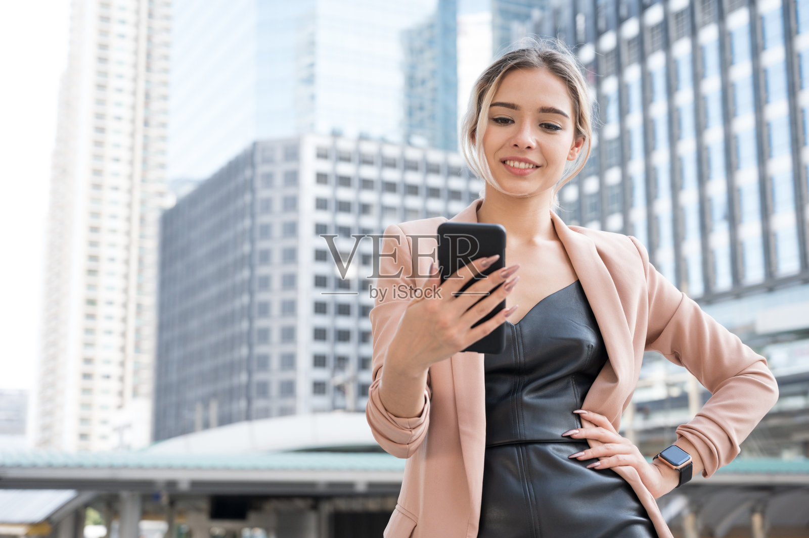 微笑的漂亮的年轻商业女性的肖像使用电话在办公室背景。照片摄影图片
