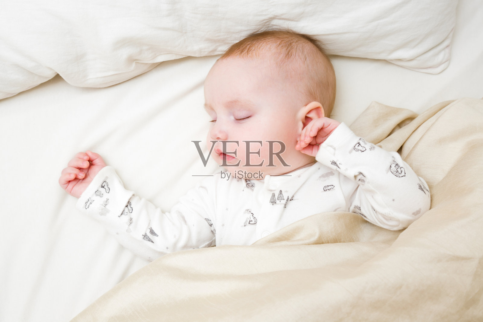 早上穿着白色紧身衣睡在父母床上的婴儿。婴儿躺着。特写镜头。自顶向下的观点。照片摄影图片