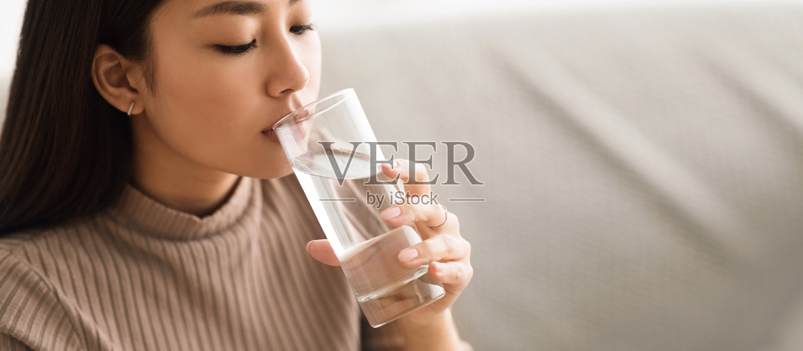 健康的液体。亚洲女孩从玻璃杯里喝干净的水照片摄影图片