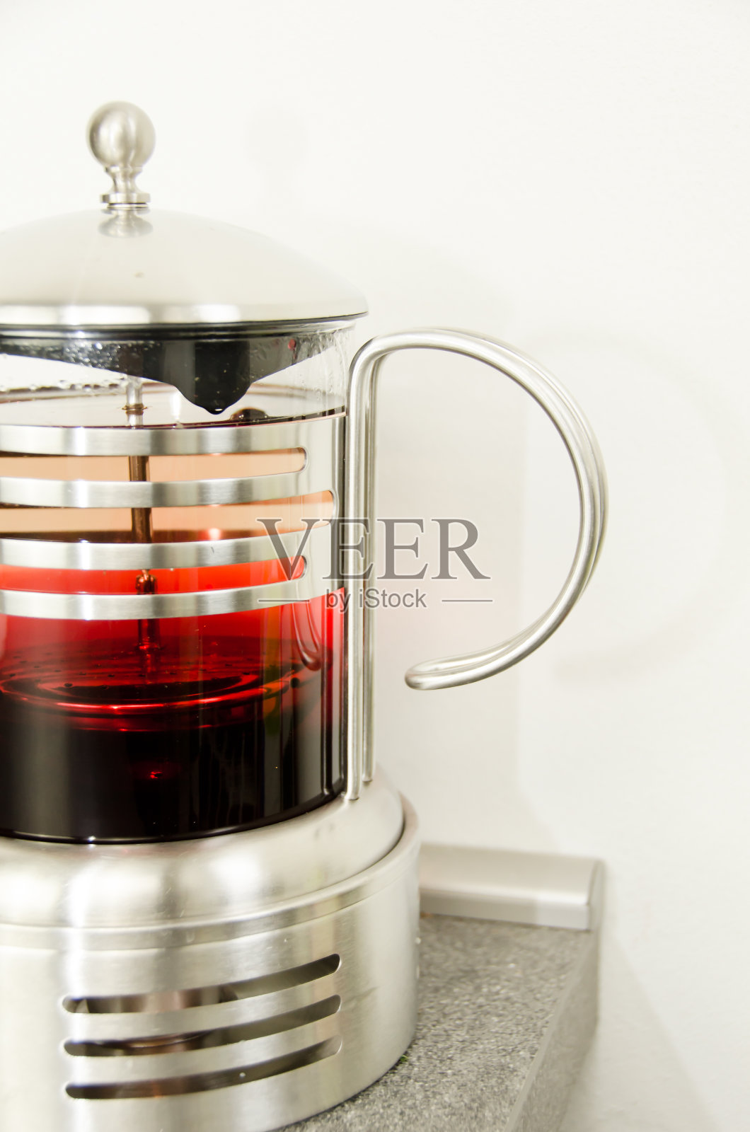 一个玻璃和金属茶壶与红色水果茶，一半的图片照片摄影图片