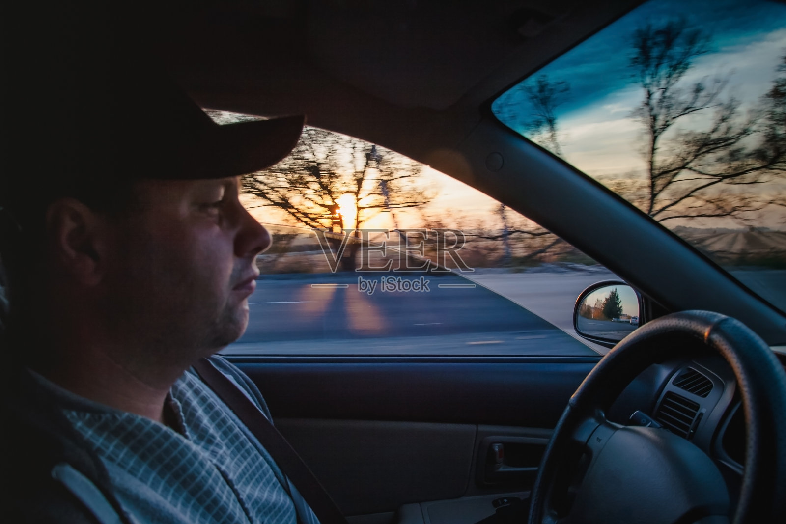 一个男人在日落时分开着一辆车，特写，模糊。概念、公路旅行和旅行、行动自由照片摄影图片