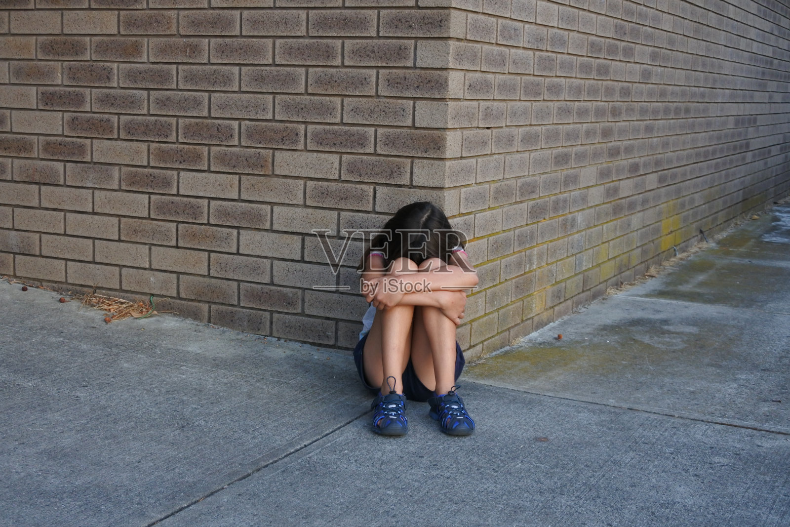 伤心的年轻女孩在女厕所外哭泣照片摄影图片