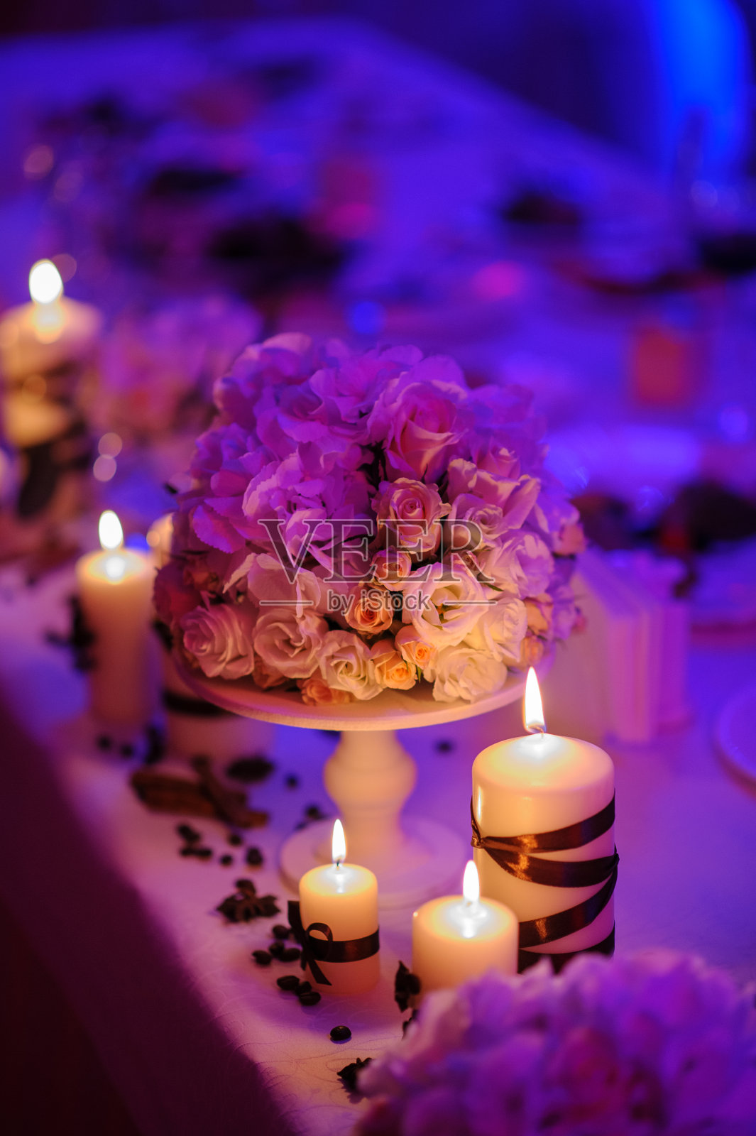 漂亮的，用鲜花装饰和红色蜡烛装饰的桌子。圣诞晚会或婚宴的装饰。照片摄影图片