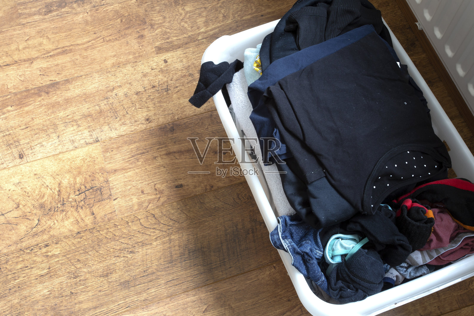 衣服放在一个洗衣篮里，放在层压板地板上，俯视图照片摄影图片