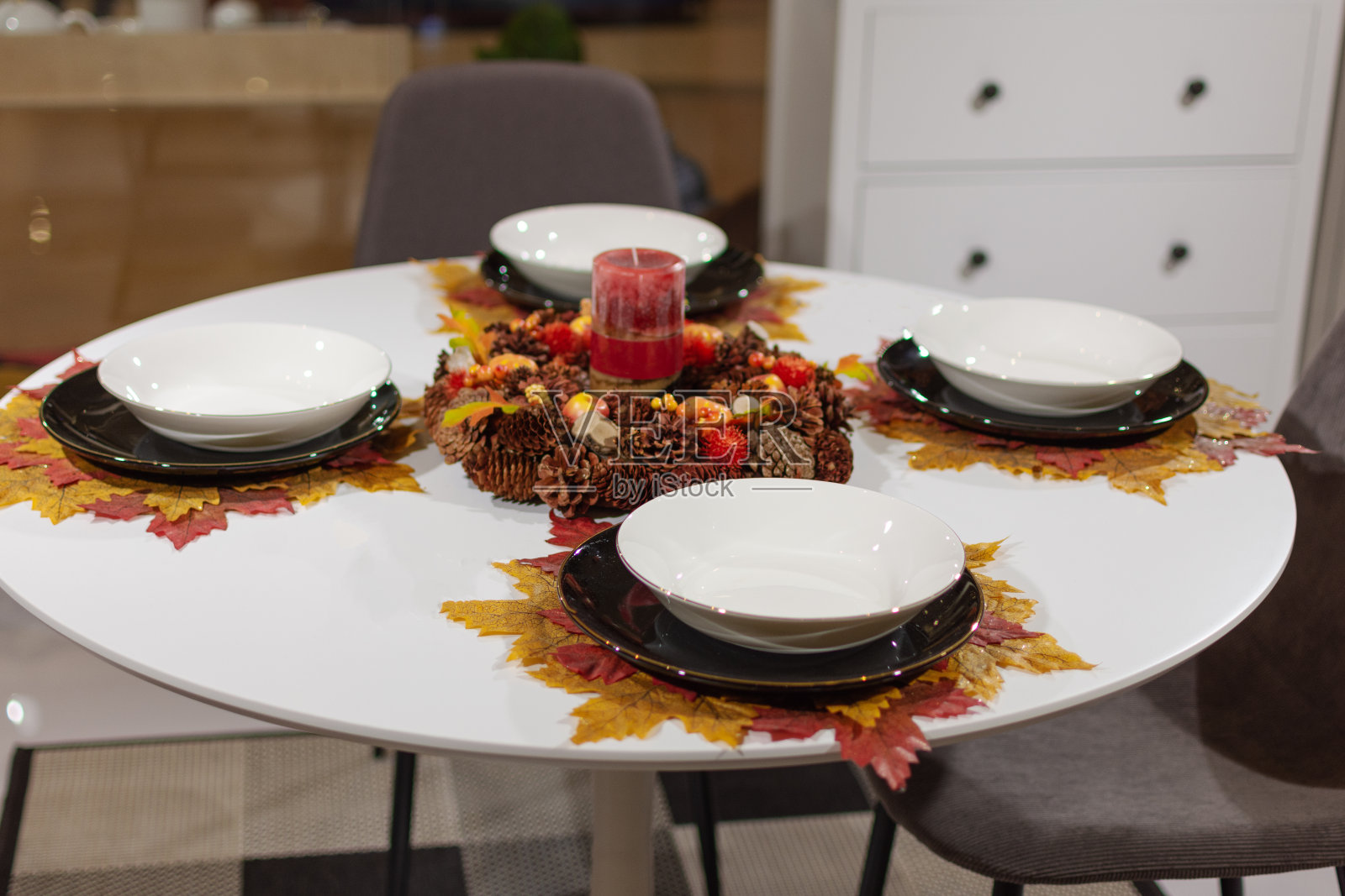 漂亮的餐桌与秋叶装饰和蜡烛。客厅里的秋餐桌。照片摄影图片