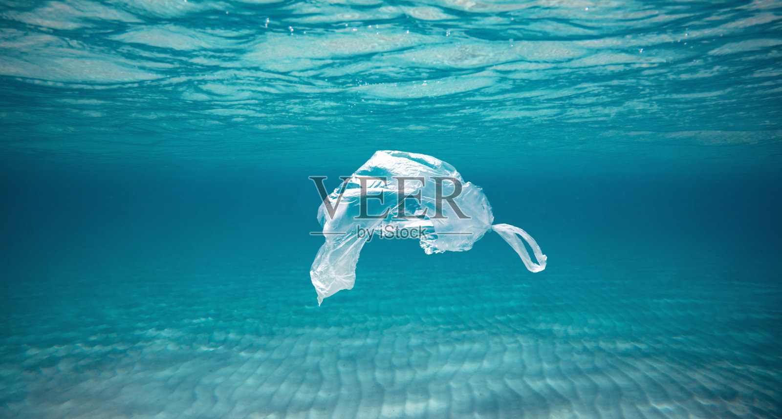 海洋污染概念，塑料袋漂浮在水中照片摄影图片