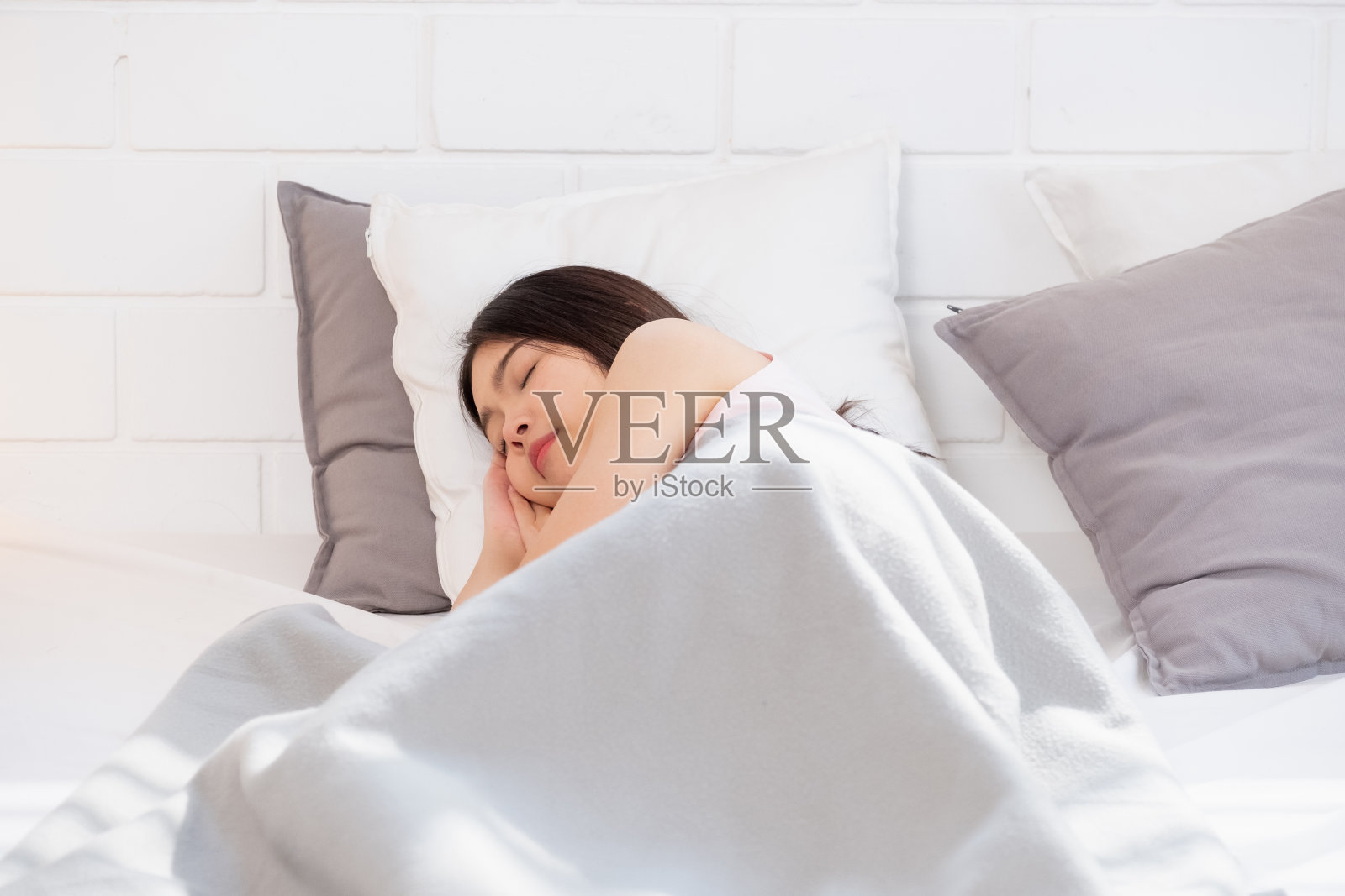早上睡在卧室里的白色床上的亚洲妇女照片摄影图片
