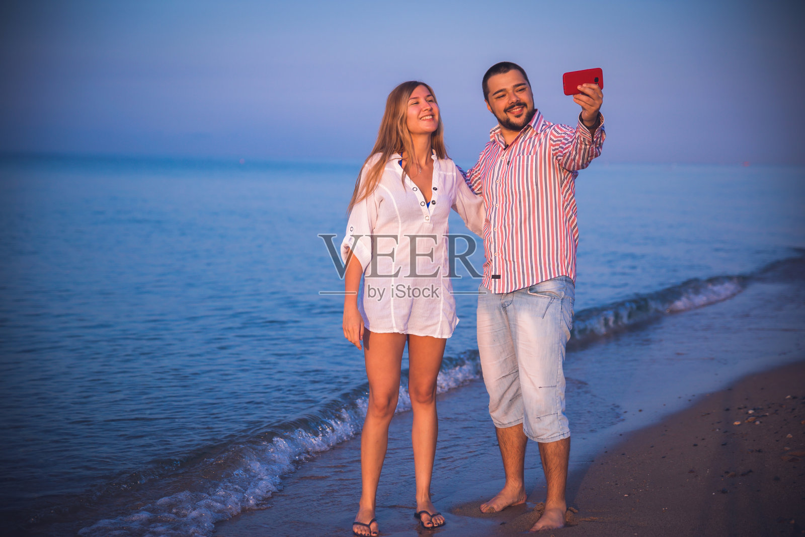 一对情侣在海滩上自拍照片摄影图片