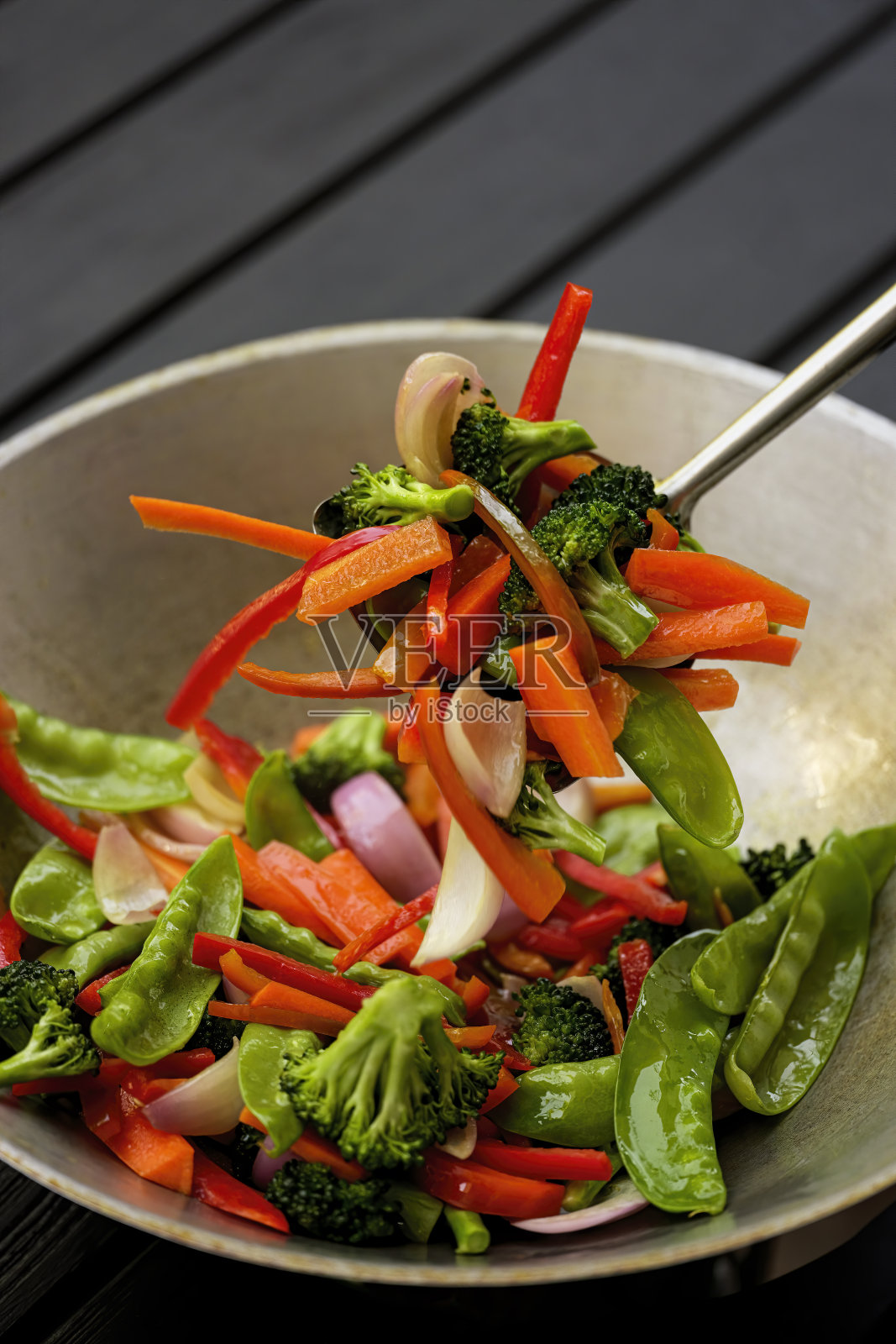 在热气腾腾的炒锅里翻炒各种新鲜的蔬菜。照片摄影图片