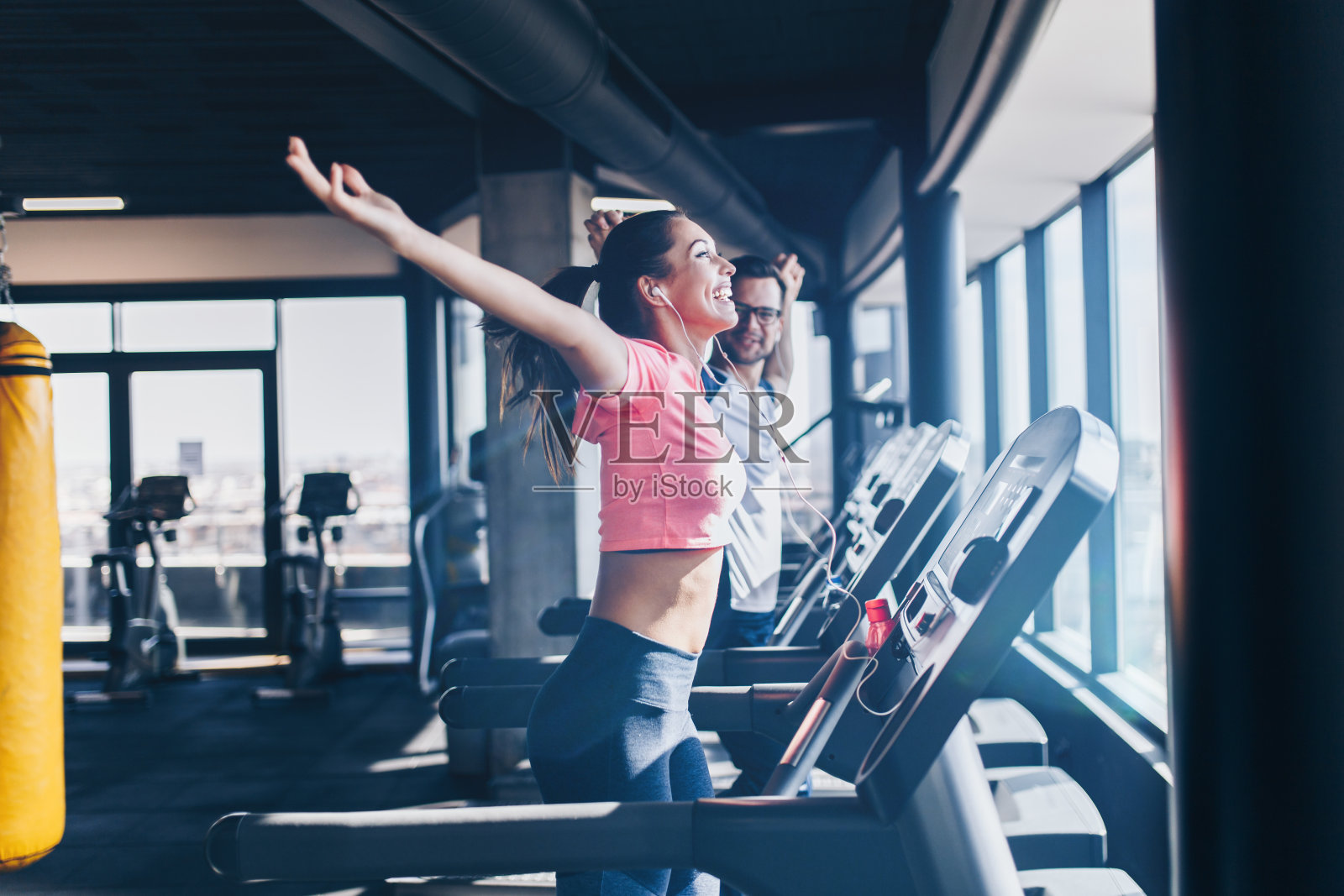 男人和女人在健身馆的跑步机上跑步照片摄影图片