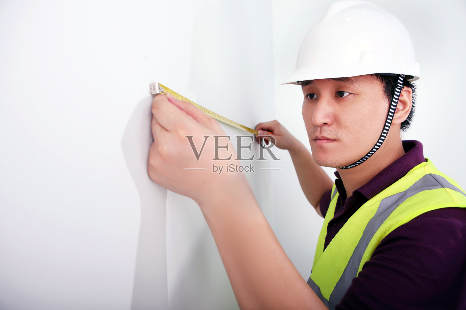 一个男性建筑工人测量墙壁照片摄影图片