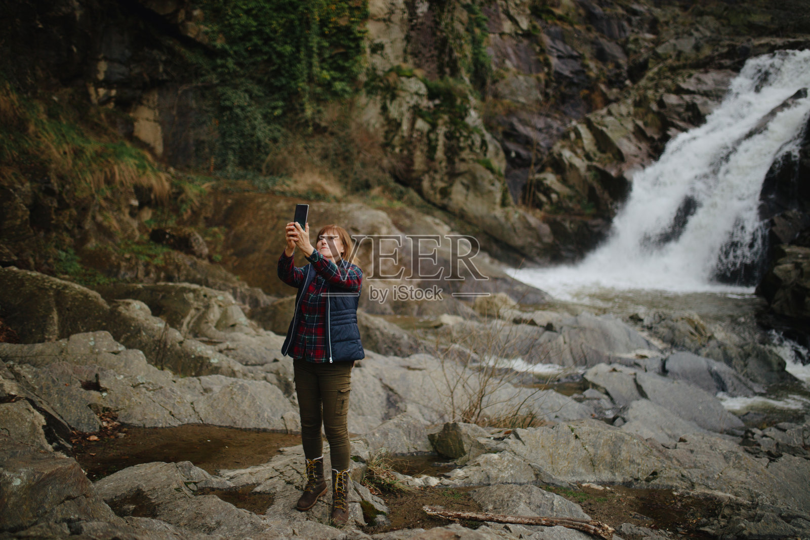 老女人在瀑布前自拍照片摄影图片