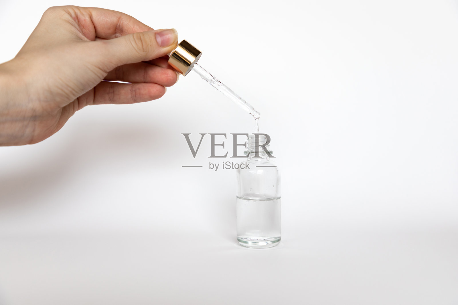 透明质酸滴从化妆品移液管在白色背景，滴管玻璃瓶模型照片摄影图片