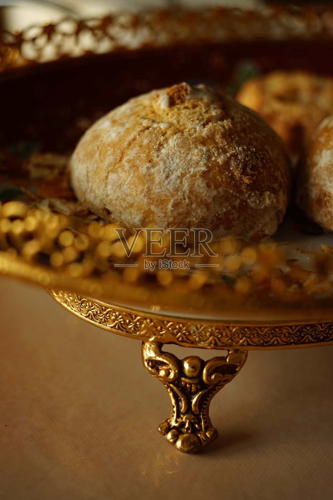 姜饼饼在一个漂亮的盘子里有一个金色雕刻图案的边和支柱。照片摄影图片