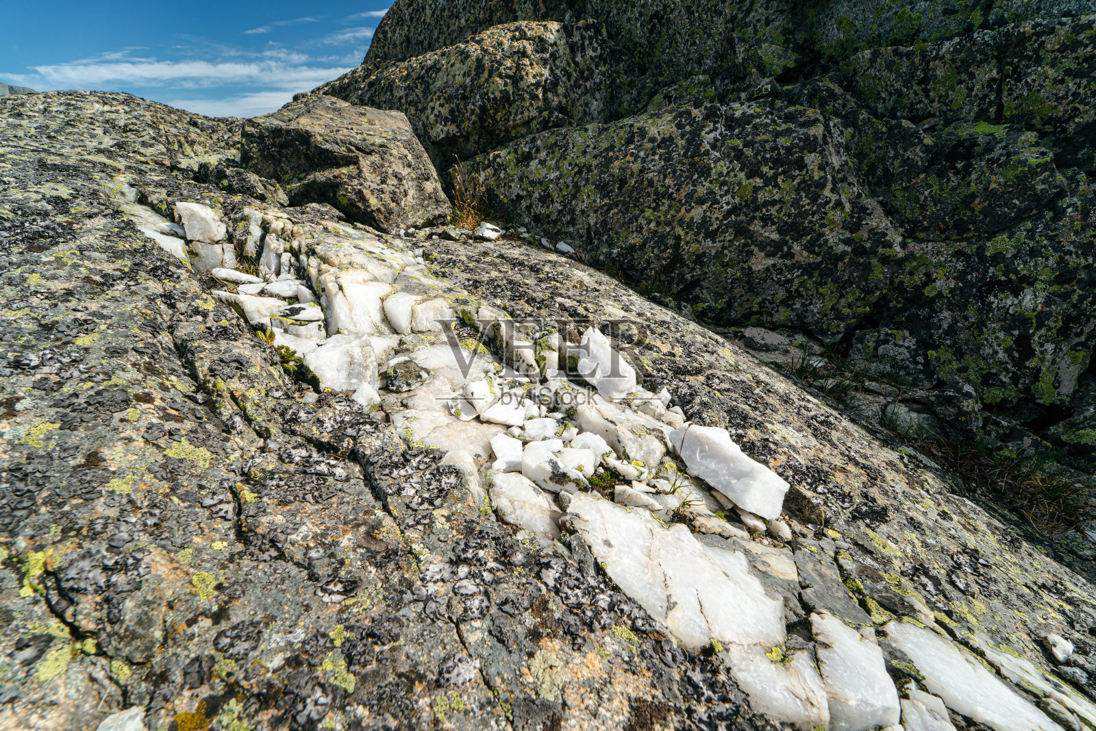 岩石里面有一层白色大理石。山区地质勘查。照片摄影图片