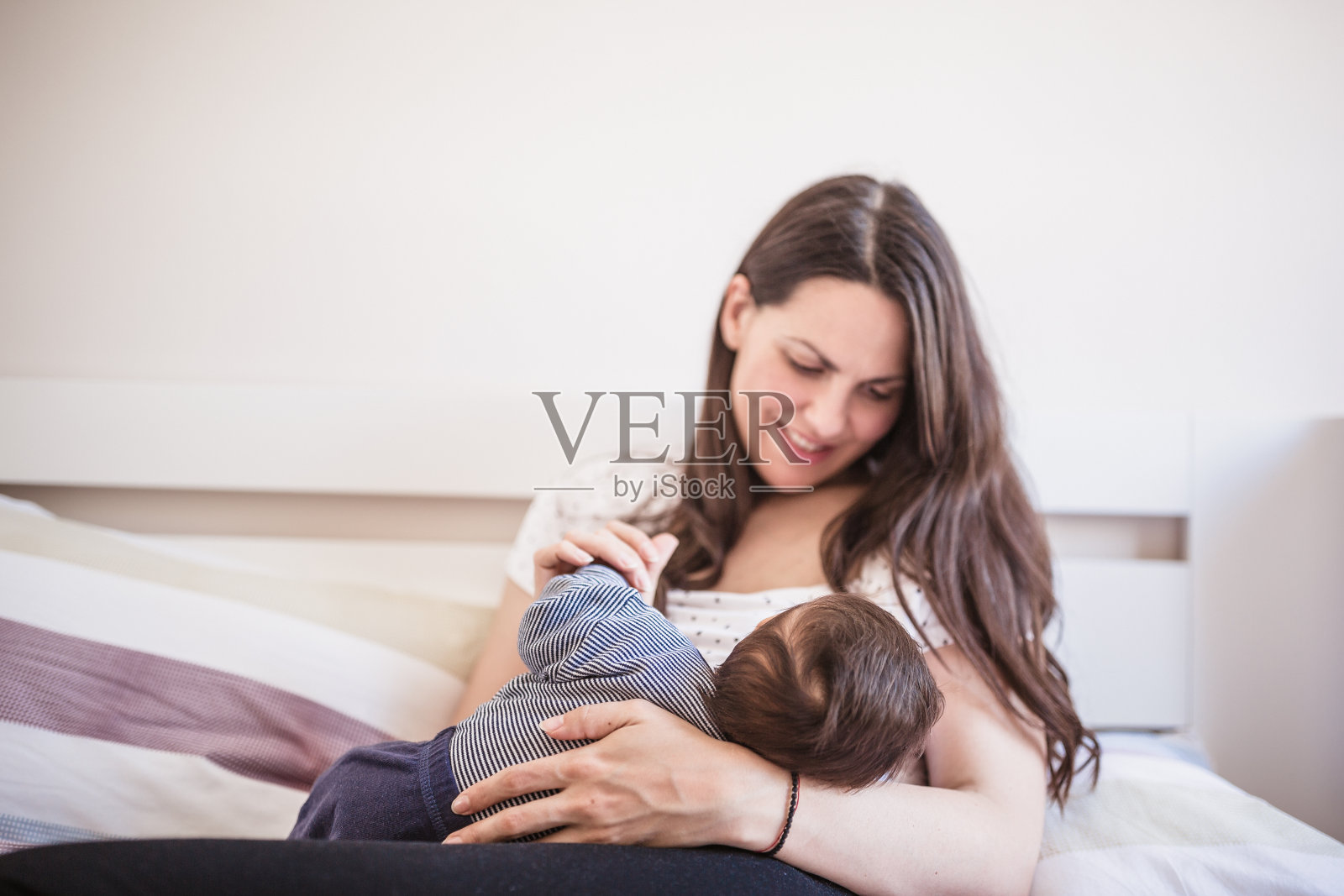 年轻的母亲正在母乳喂养她的男婴照片摄影图片