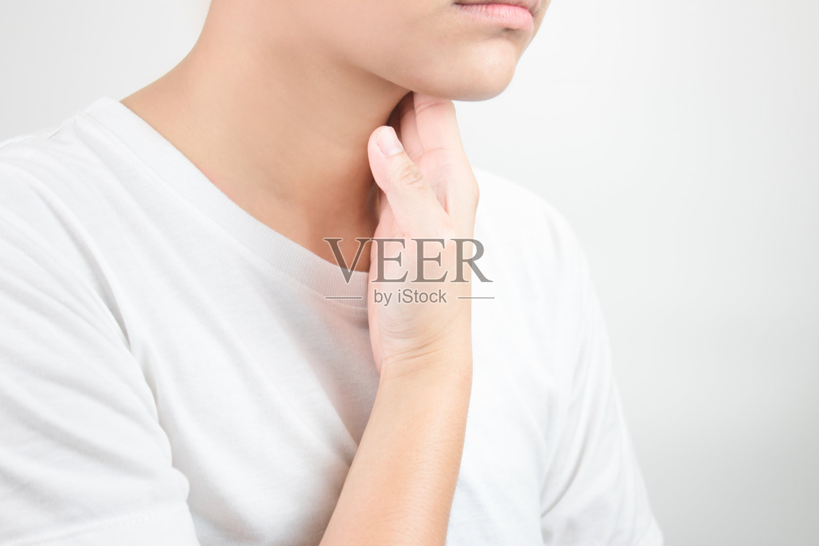 喉咙痛。由于空气干燥而没有水分。亚洲人用手触摸脖子。保健和医学概念照片摄影图片