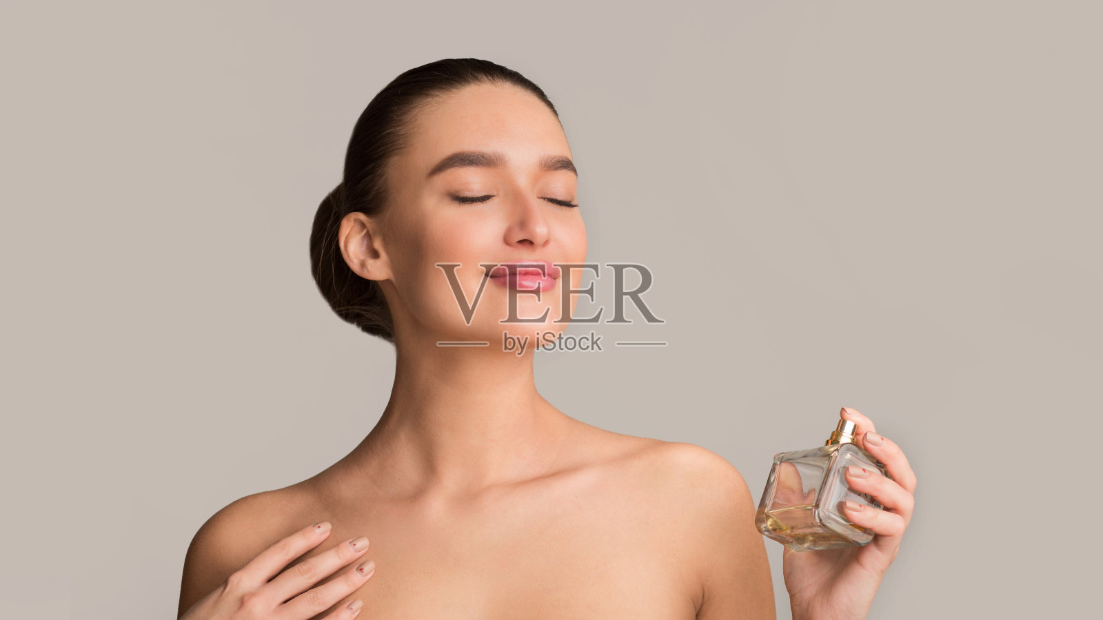 女孩在脖子上喷香水，享受香味照片摄影图片