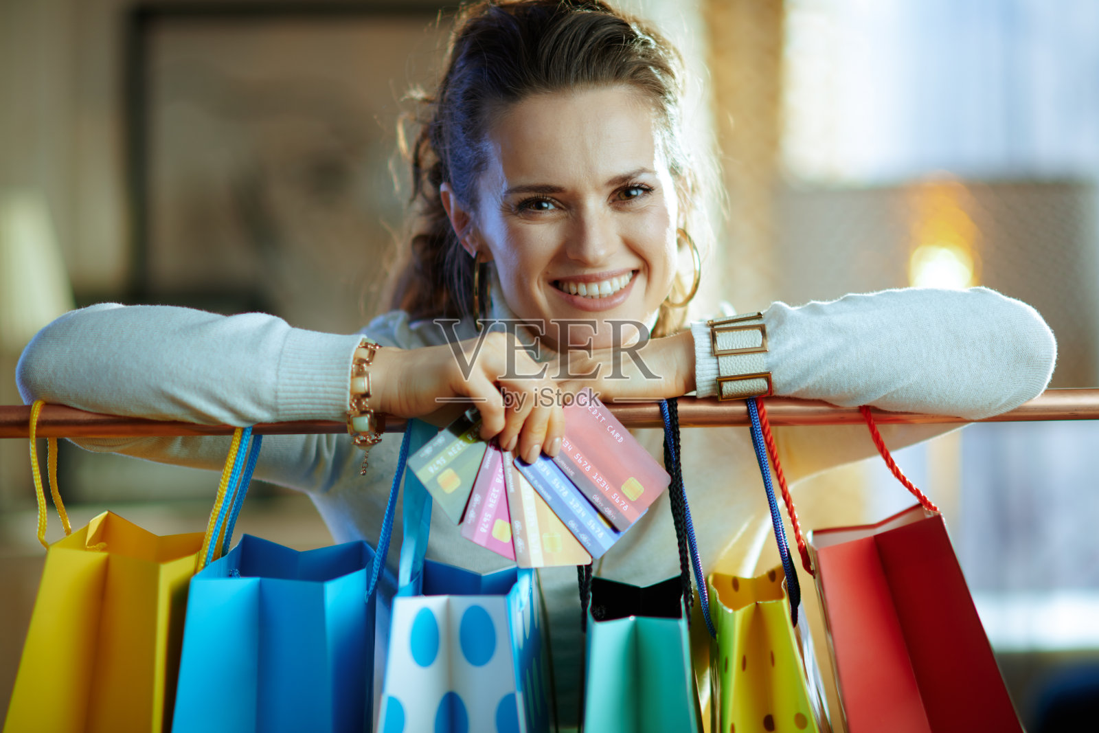 微笑的女人靠近购物袋与信用卡扇照片摄影图片