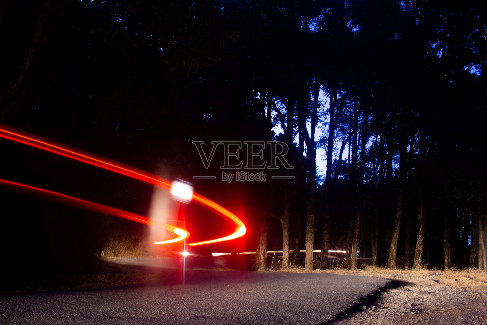 长曝光拍摄一辆汽车在运动中留下灯光痕迹。照片摄影图片