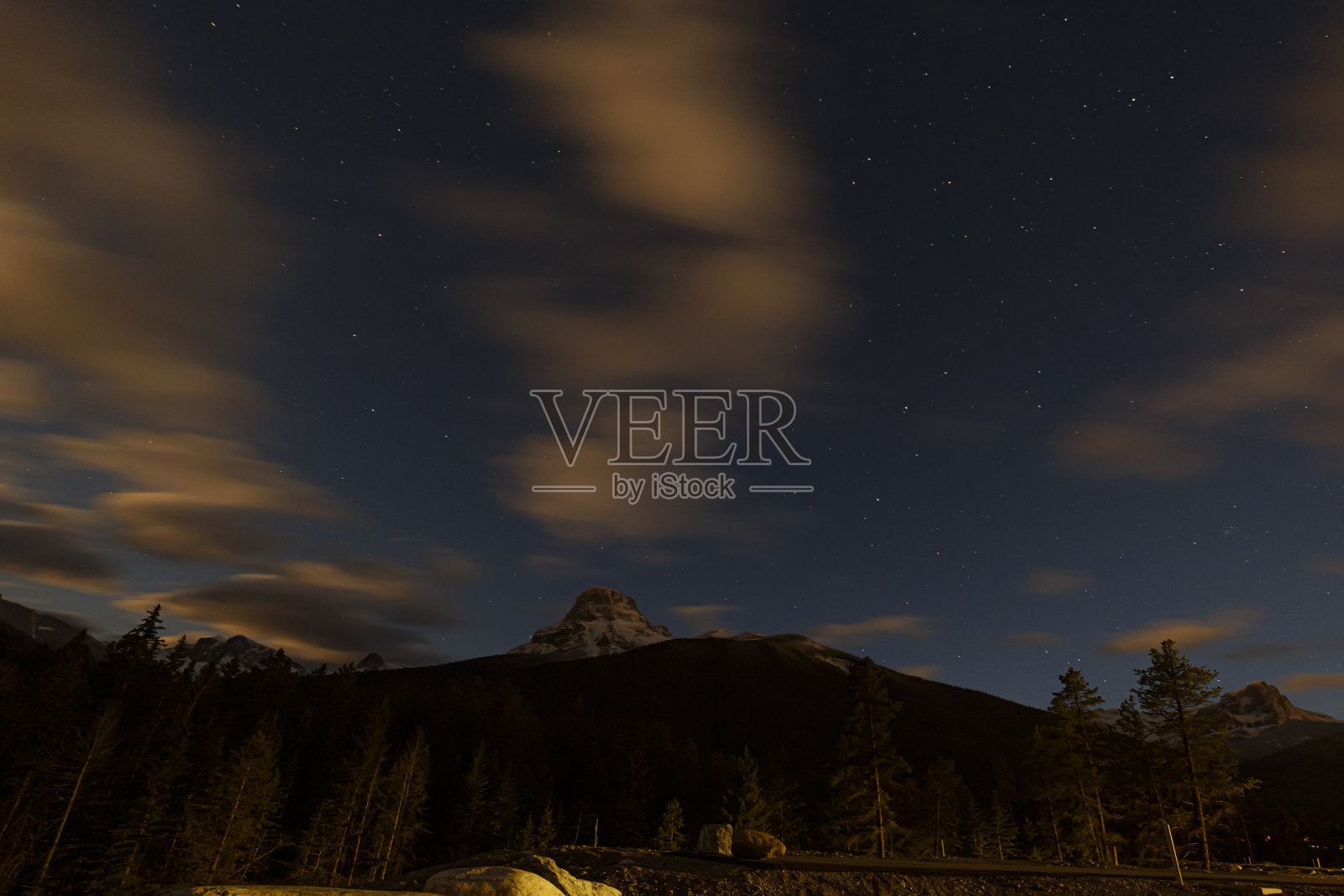 黑暗的山。背景是有星星和云彩的夜空。春溪,加拿大照片摄影图片