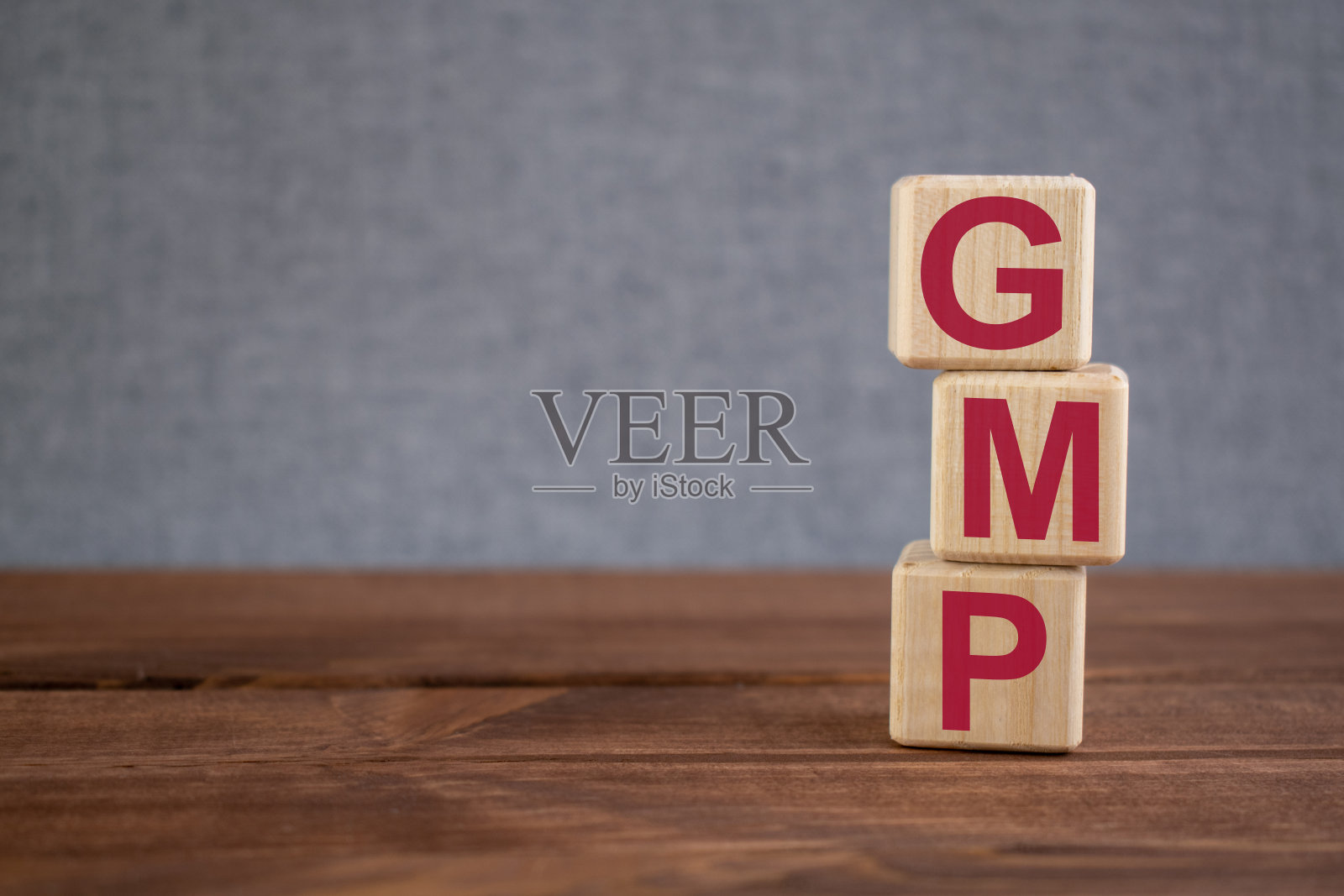 GMP(良好生产规范)首字母缩写在深色木质背景上的木方。经营理念。照片摄影图片
