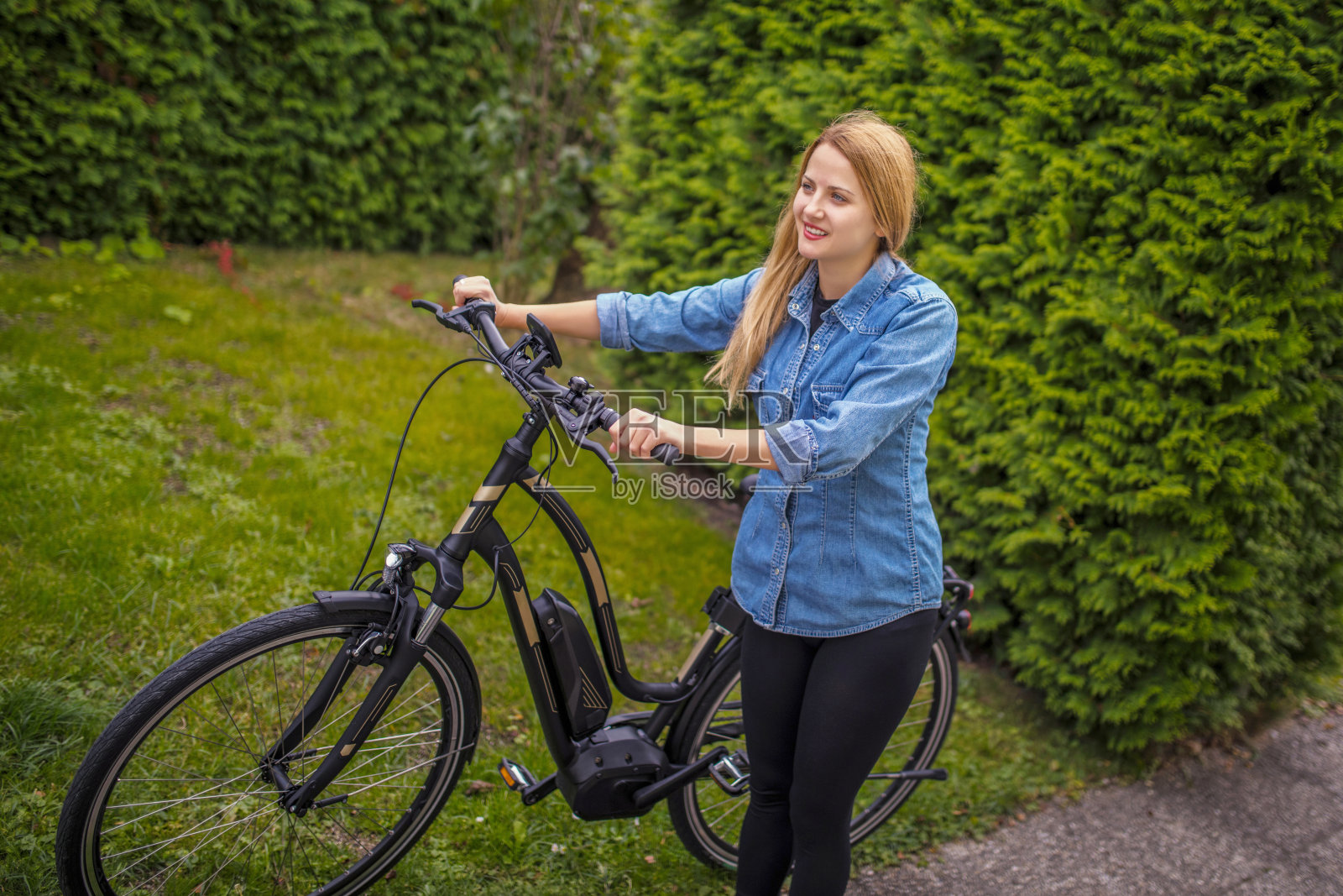 快乐的年轻女子与电动自行车照片摄影图片