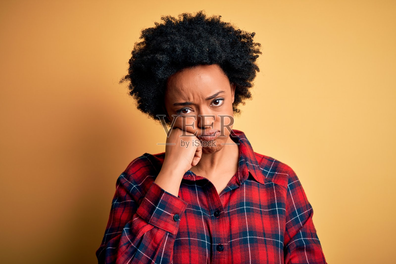 年轻美丽的非洲裔美国女人与卷发穿着休闲衬衫思考看起来疲倦和厌倦与抑郁症问题交叉双臂。照片摄影图片