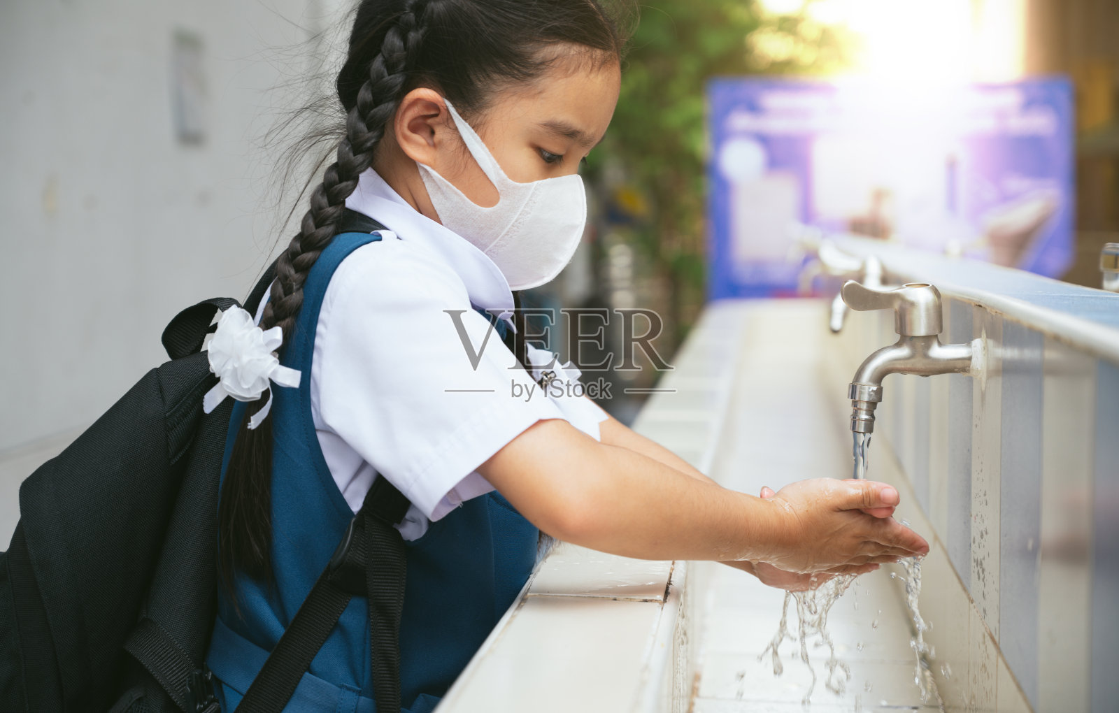 亚洲学生在学校的室外洗手池洗手。预防传染病，瘟疫。儿童健康，保护Covid - 19病毒，节约用水，清洁，自来水。照片摄影图片