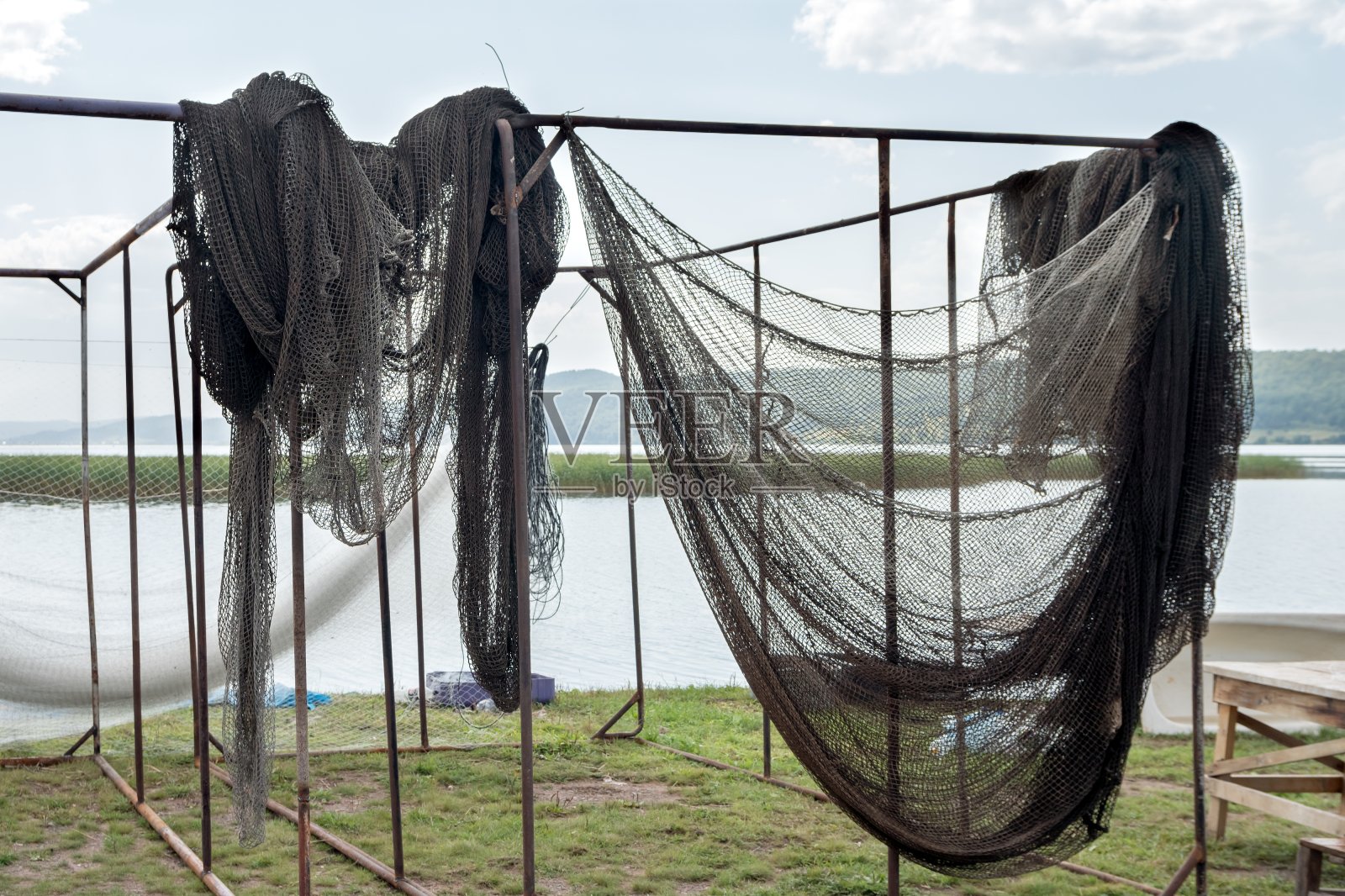 夏天，渔网在湖上的横木上晒干。照片摄影图片