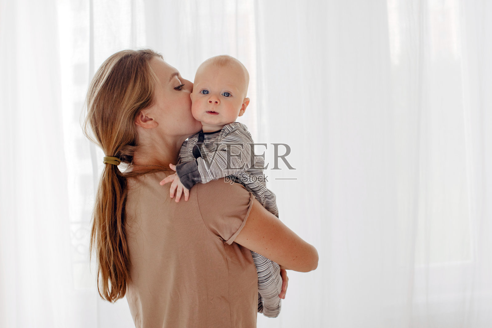妈妈亲吻和拥抱婴儿照片摄影图片