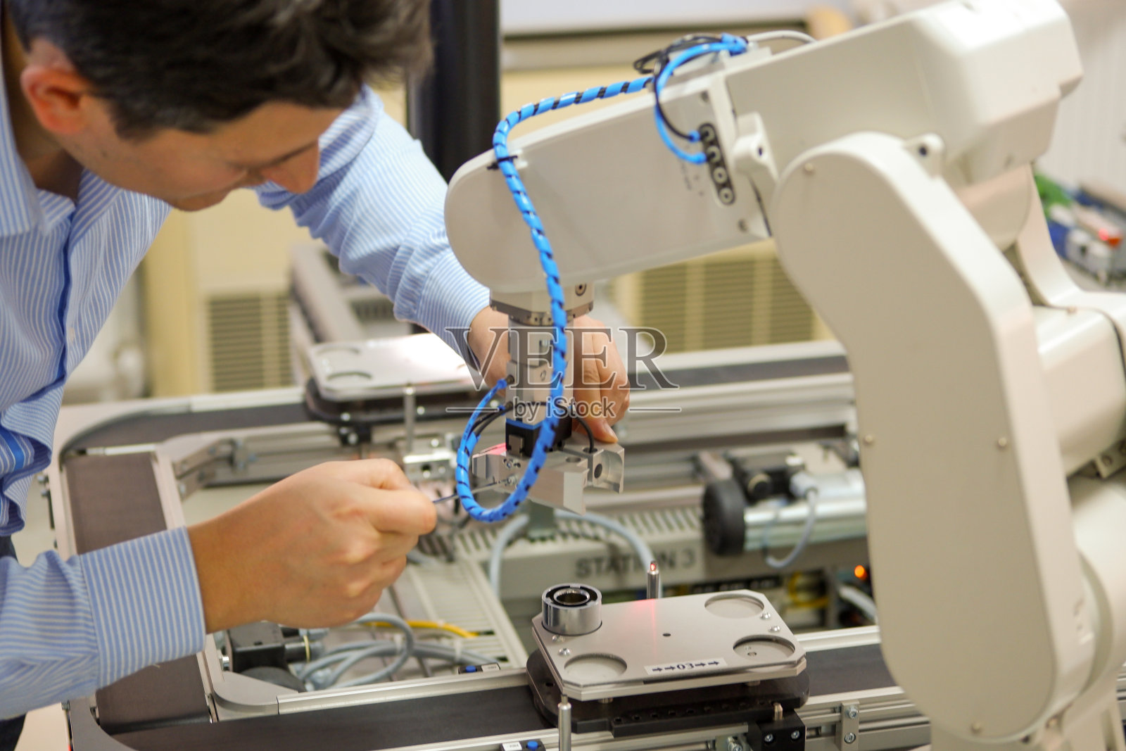 维修工程师(机械师)在技术实验室修理机器手臂照片摄影图片