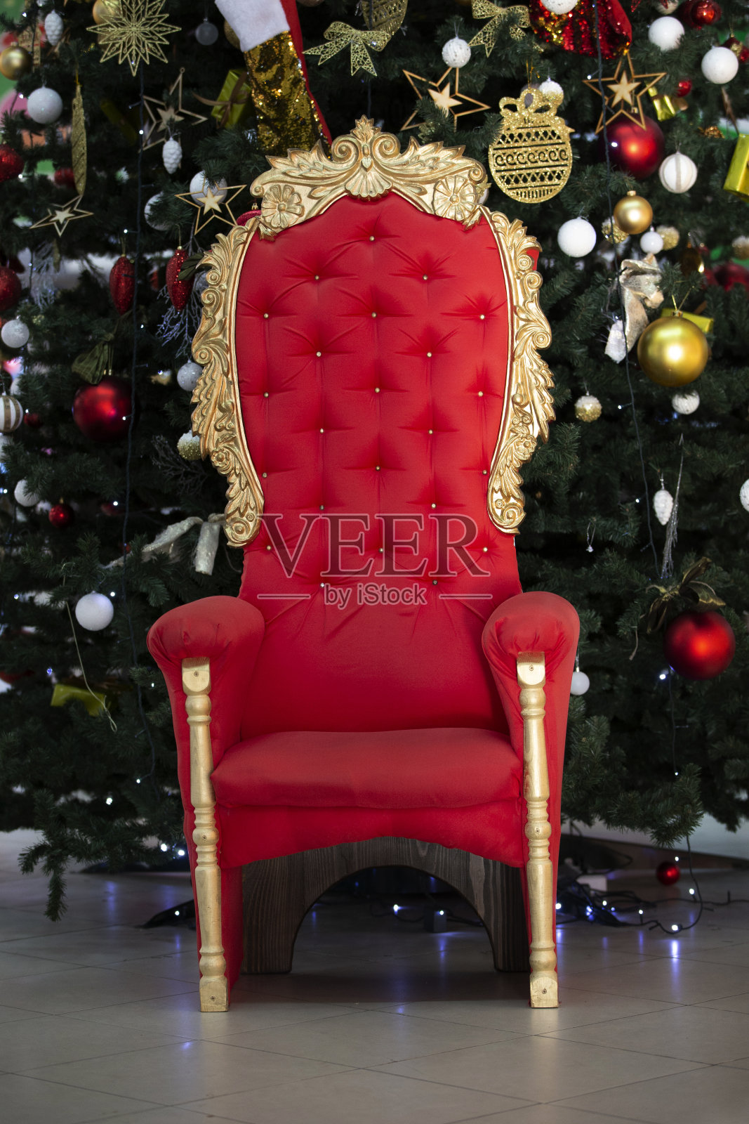 圣诞树上的红色宝座。圣诞老人的扶手椅。照片摄影图片