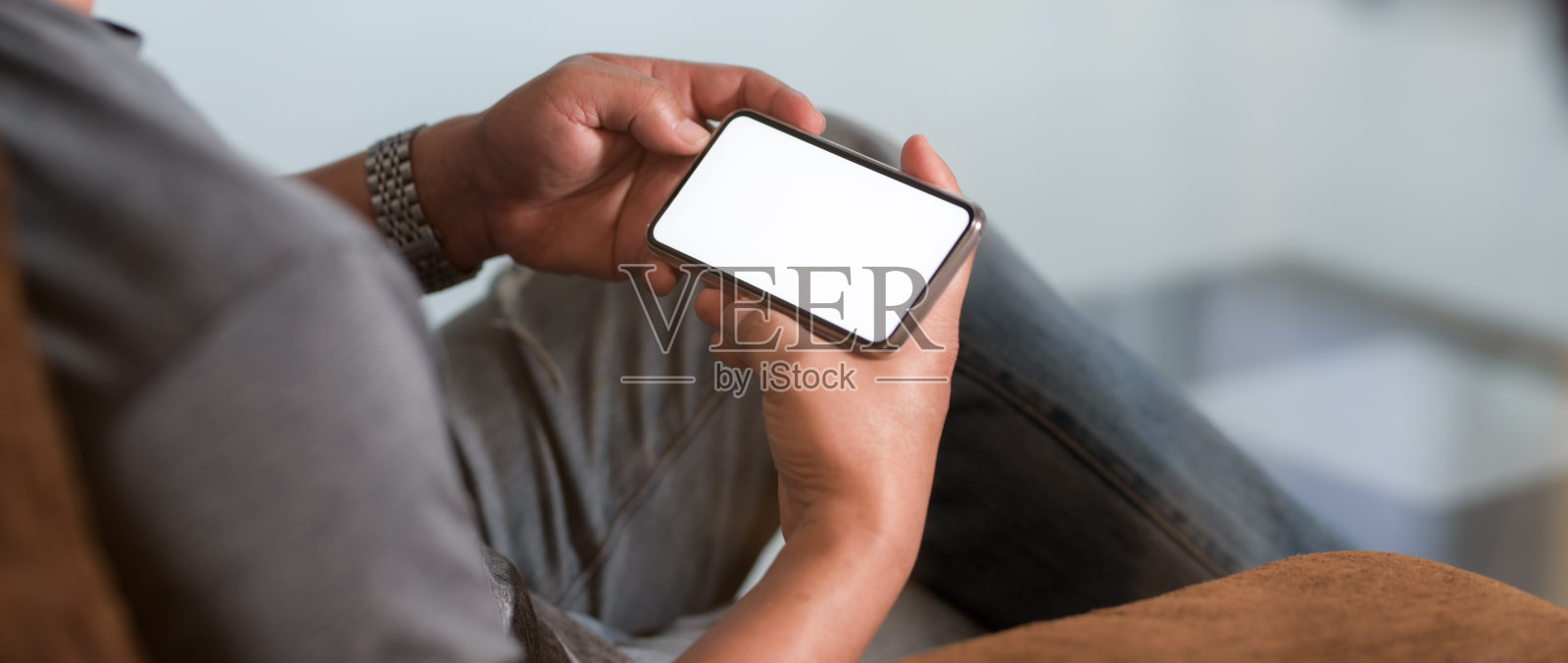 一名男子手持水平空白屏幕智能手机的剪影照片摄影图片