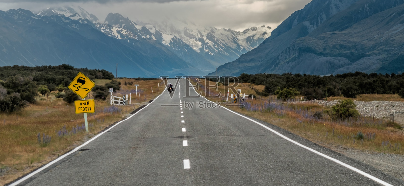 新西兰库克山(奥拉基)附近的道路上有摩托车手和路标“霜冻时滑”在新西兰南岛照片摄影图片