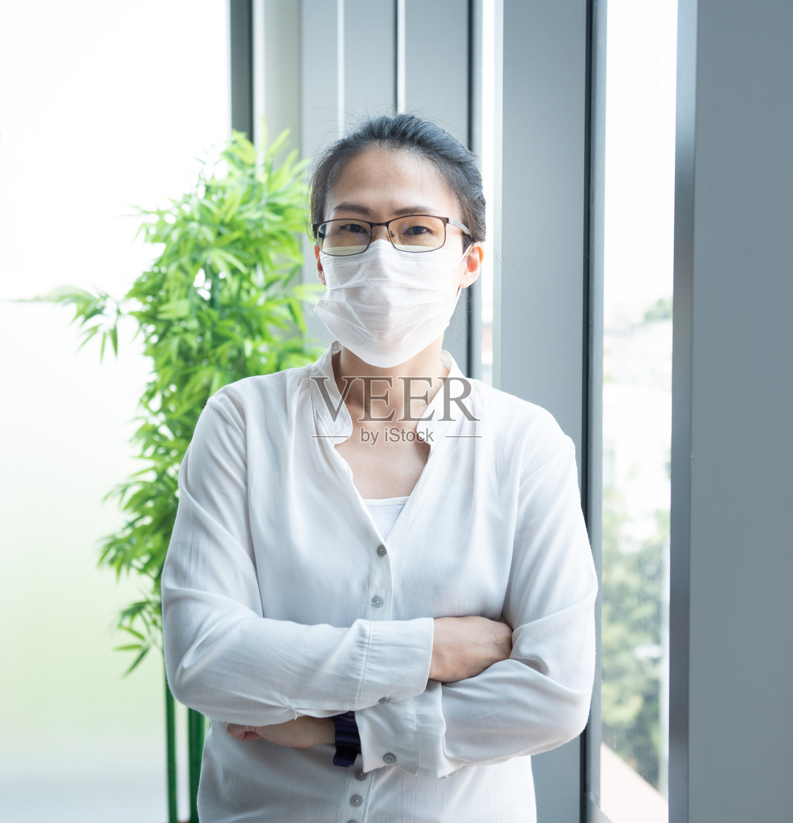 亚洲商务女性戴着防毒面具在办公室。预防PM 2.5空气污染，防止冠状病毒或covid-19病毒的世界大流行，卫生保健和医学概念照片摄影图片