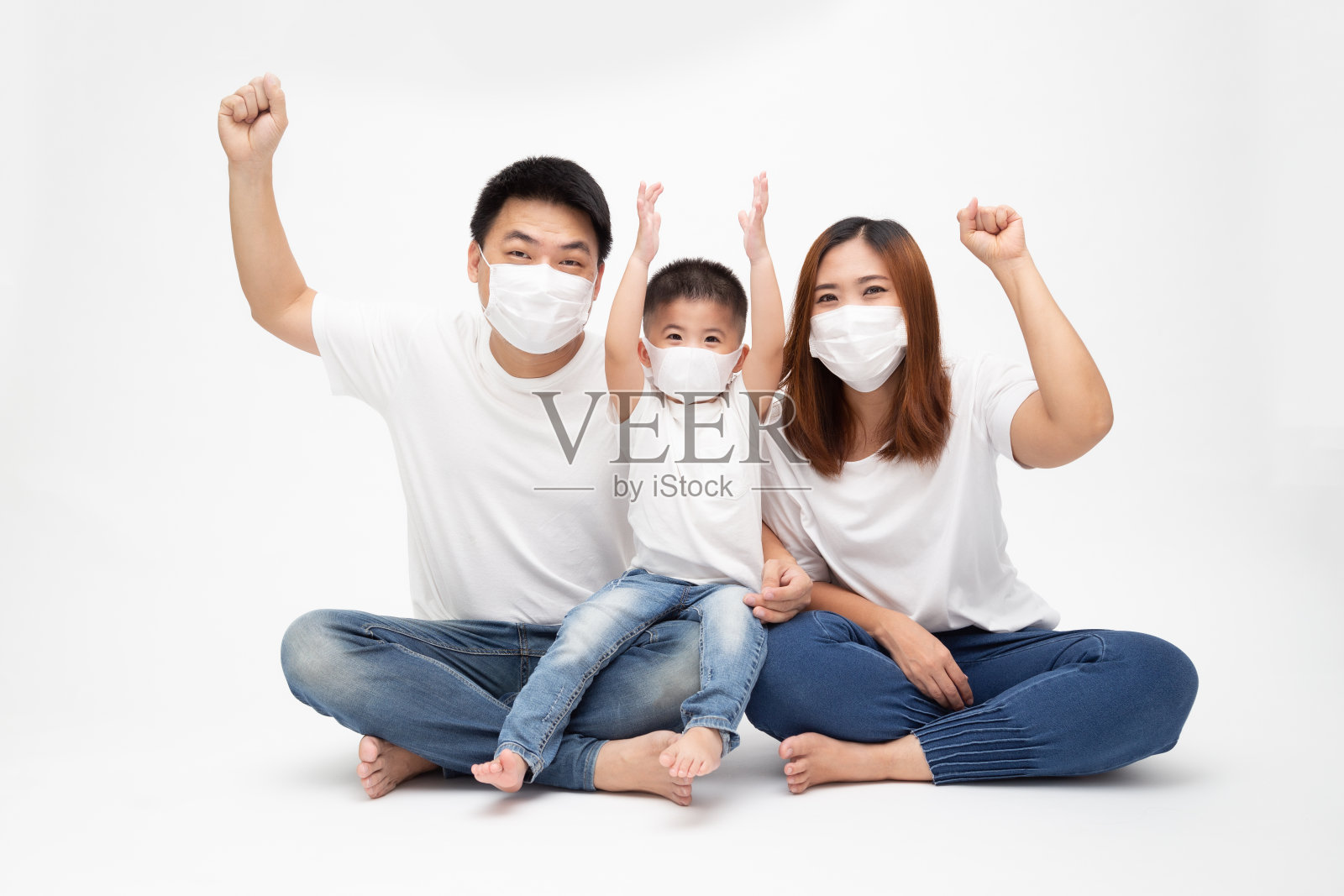 亚洲家庭戴着医用防护口罩预防新型冠状病毒感染，手牵手坐在地板上隔离白色背景。家庭保护免受污染空气的概念照片摄影图片