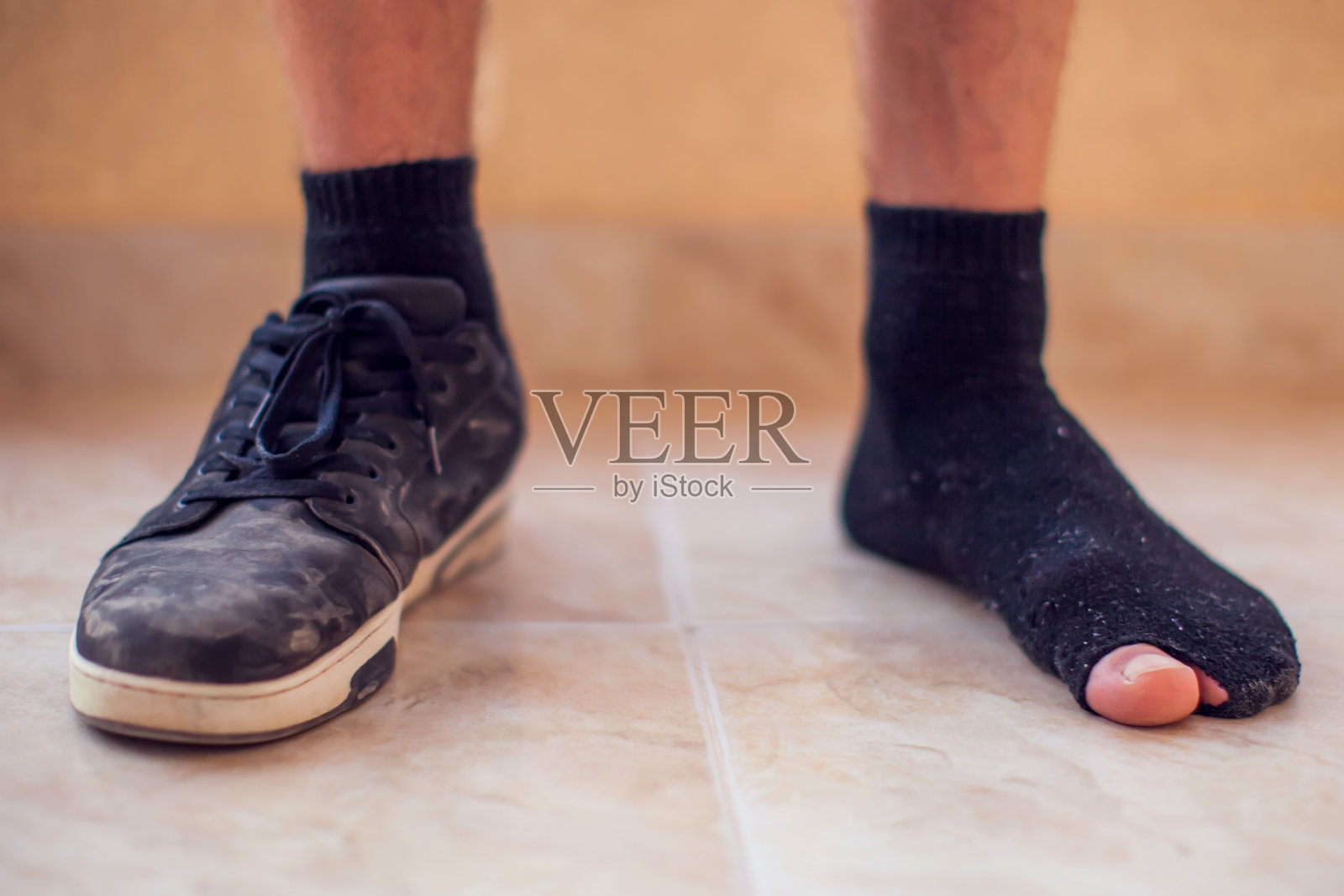 穿着破袜子和脏鞋子的男人。贫穷和不整洁的概念照片摄影图片