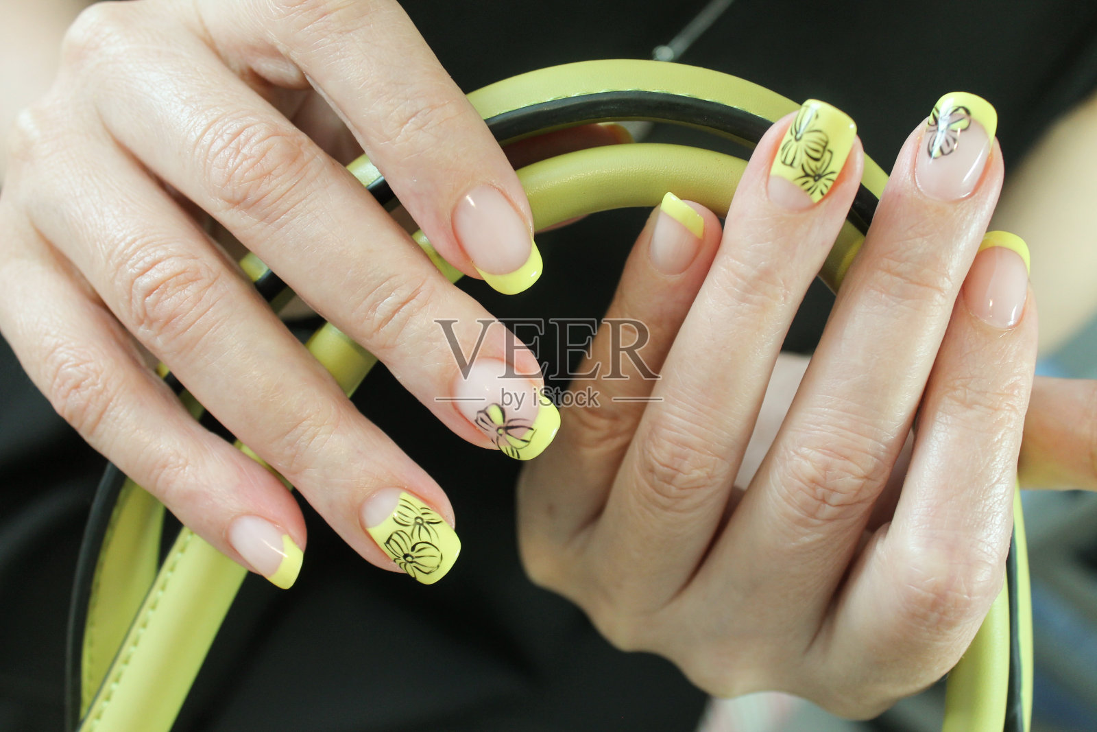 美丽的创意法国美甲啫喱指甲油的自然指甲与设计的指甲油，手绘在一个时尚的女人的手上照片摄影图片