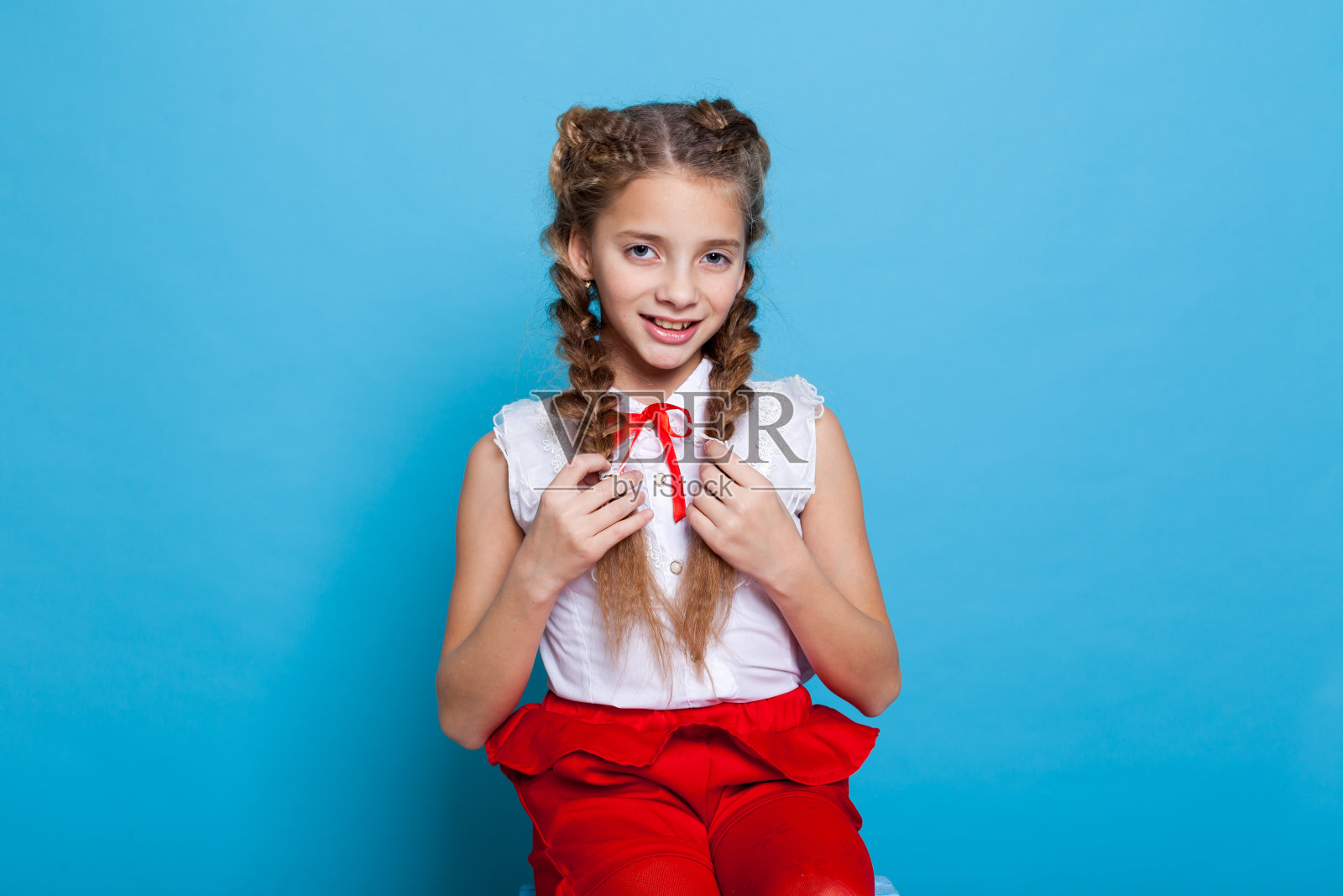 女学生女孩穿着红白色的裙子在蓝色的背景照片摄影图片