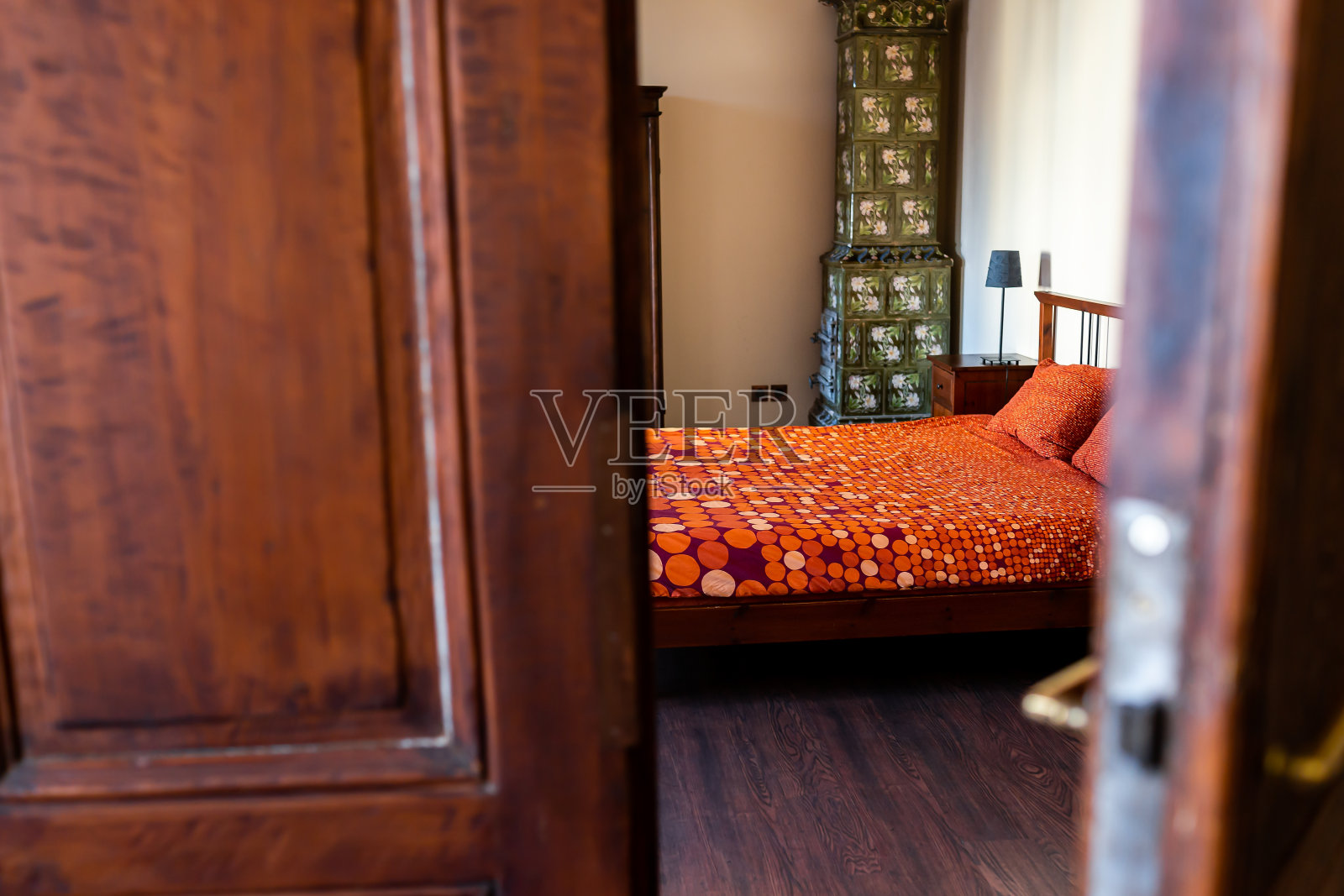 古董复古复古的木制卧室与床在房间与老式的装饰和烟囱壁炉在家里和框架前景的开放式门在欧洲照片摄影图片
