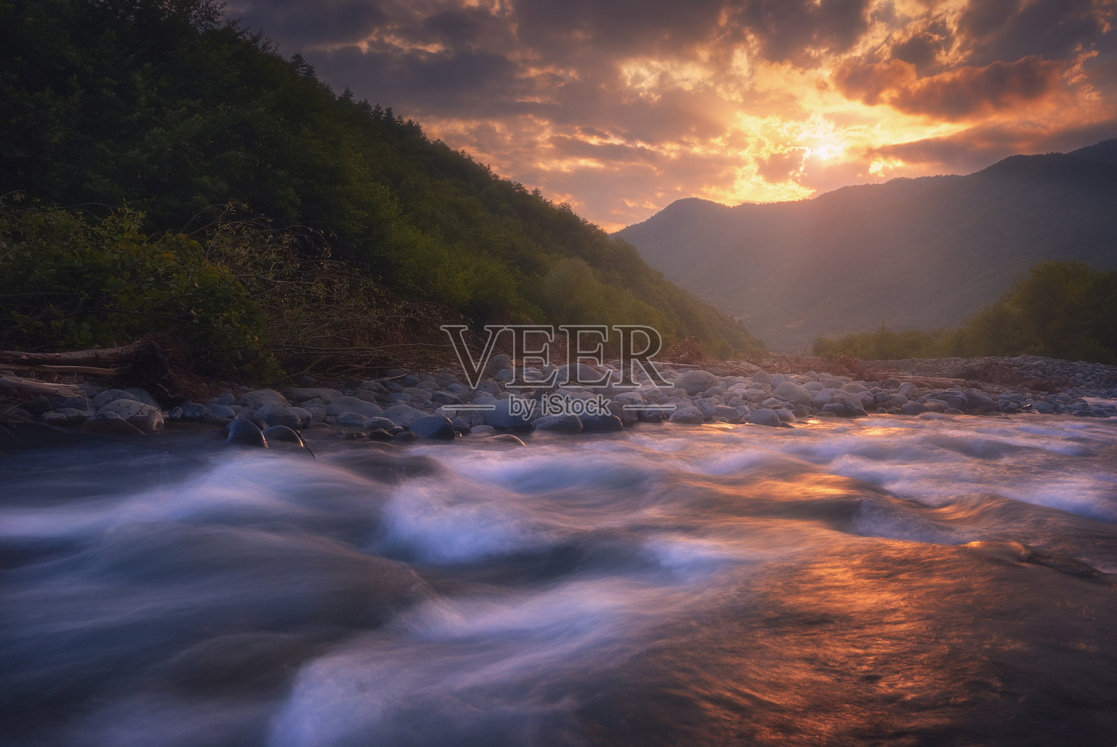 美丽的日落在快速流动的山河。山中缤纷的夏夜。格鲁吉亚高加索照片摄影图片