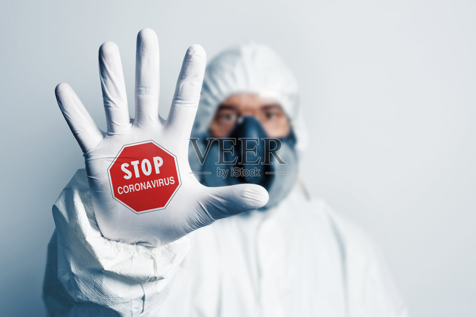 身着防护服的医护人员手持“阻止冠状病毒”的手势照片摄影图片