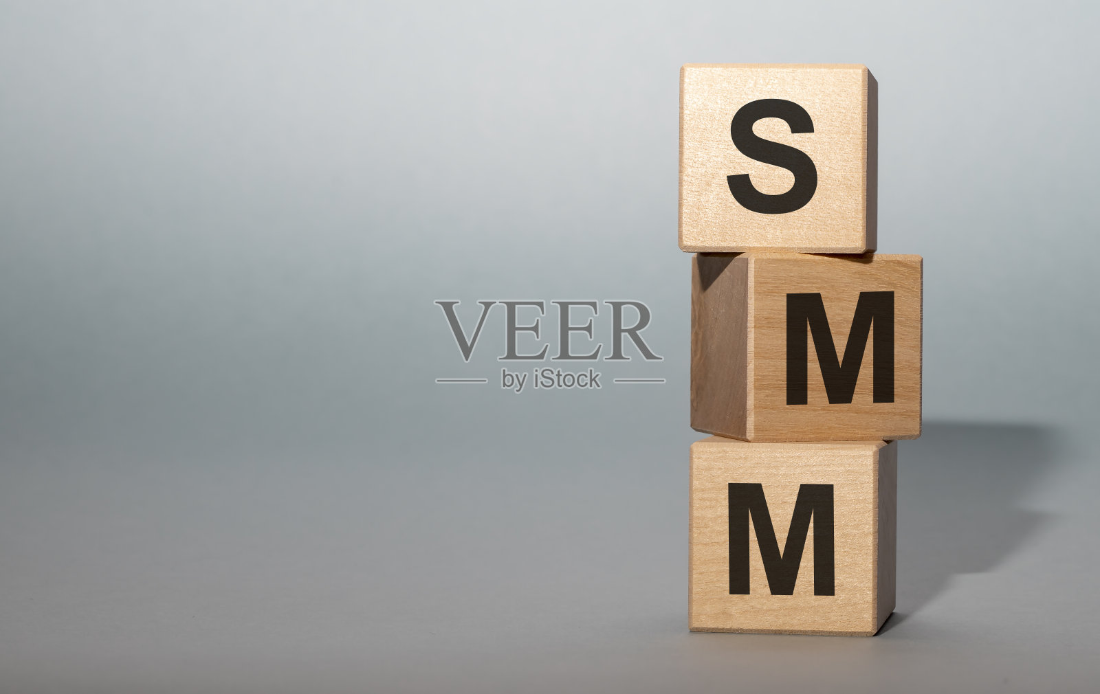 SMM -社会媒体营销-字母在木立方体上灰蓝色的背景照片摄影图片
