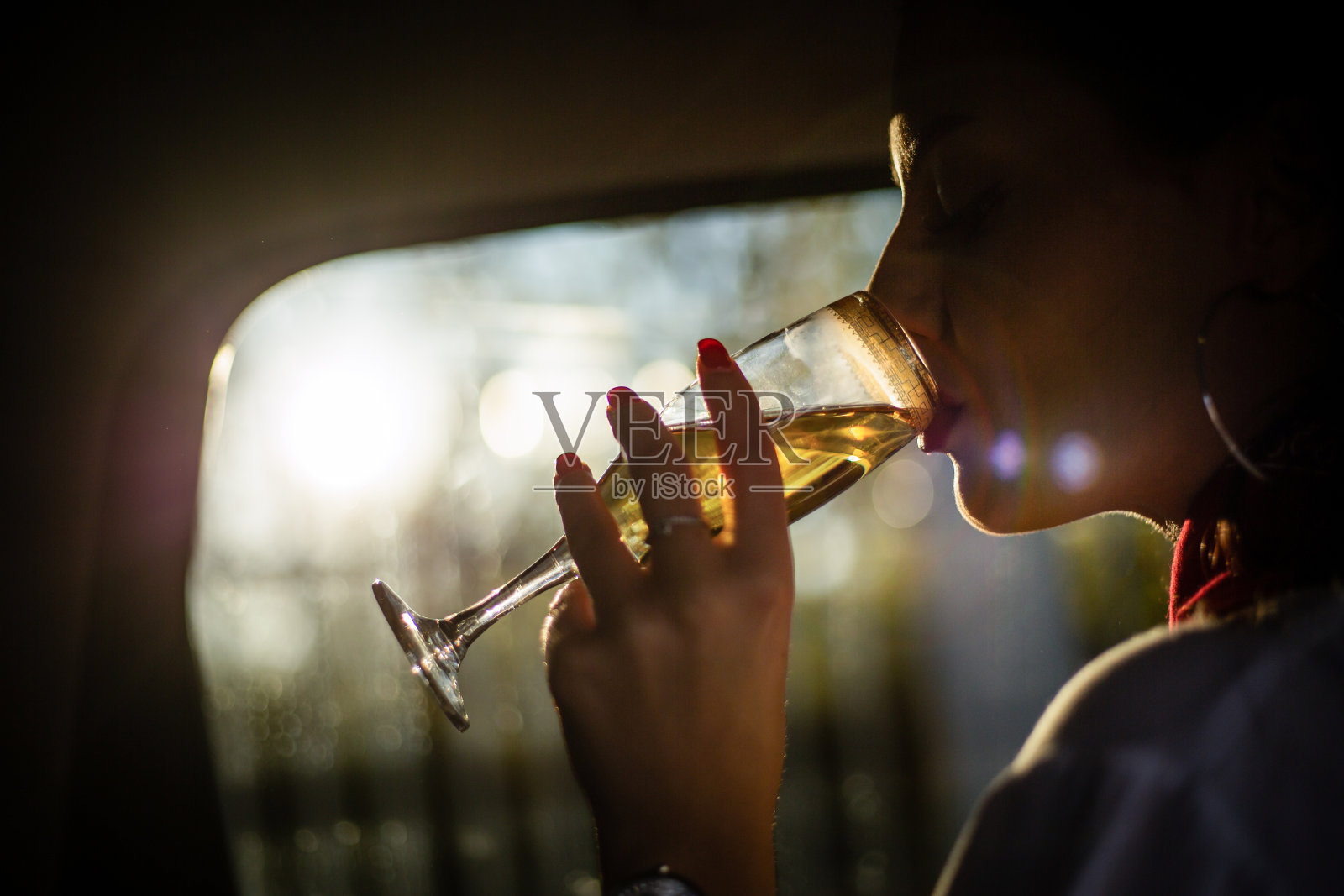 女商人开车旅行，坐在后座喝香槟照片摄影图片