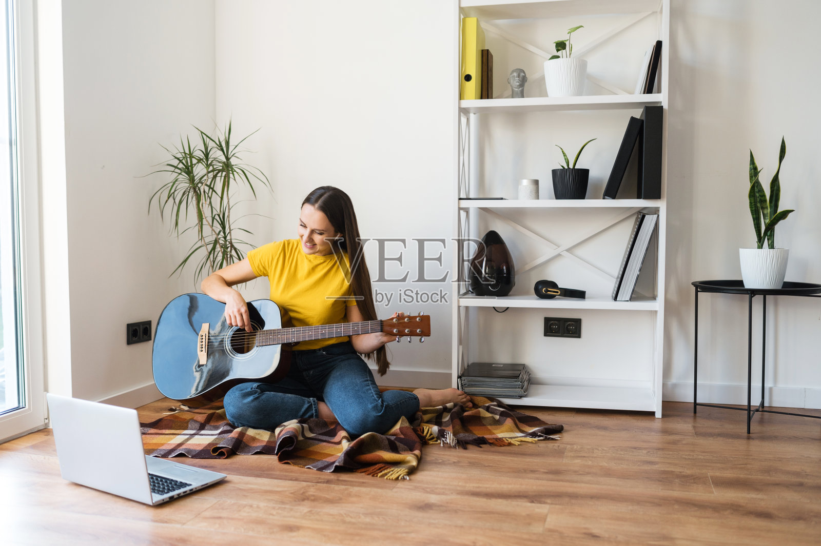 一个女人在看吉他弹奏教程视频照片摄影图片