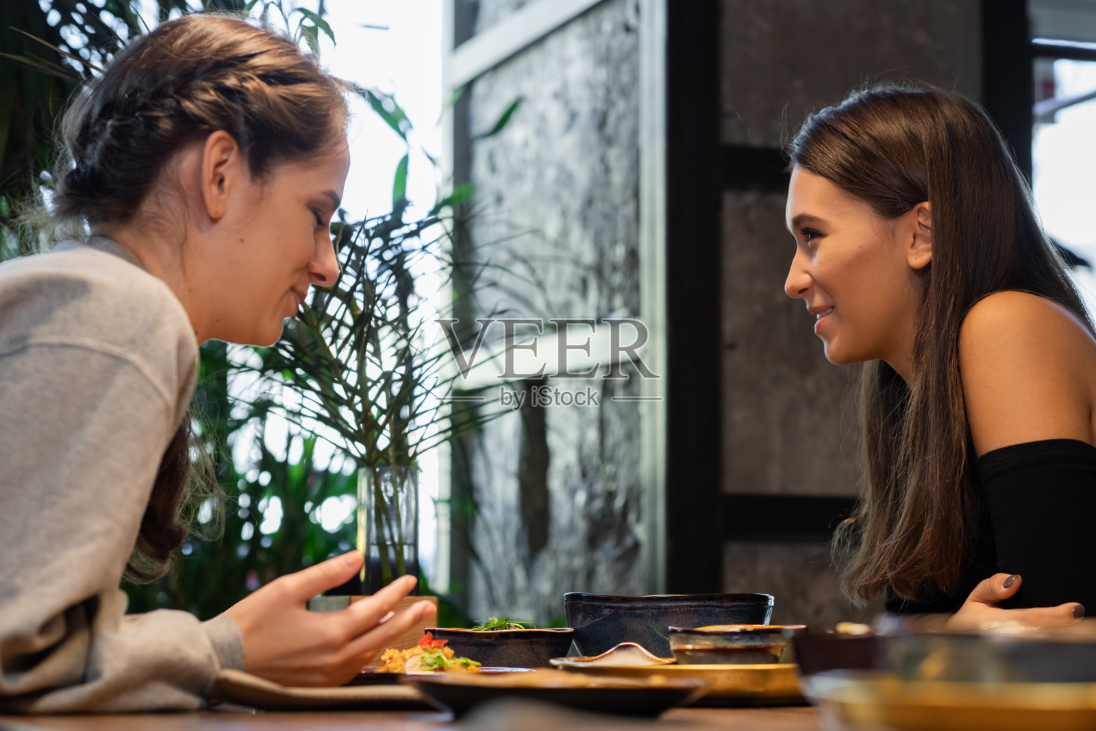 两个女性朋友在咖啡馆边聊天边吃零食照片摄影图片