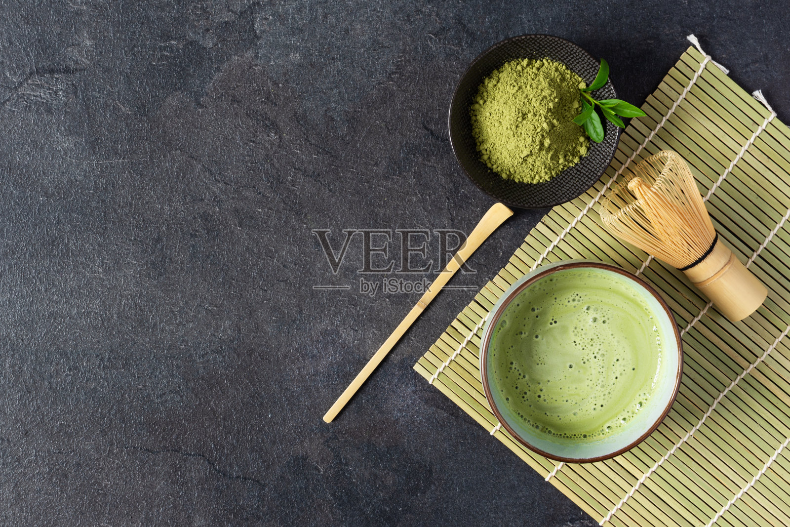 绿茶抹茶饮料和茶配件上的黑色背景俯视图。日本茶道观念。照片摄影图片