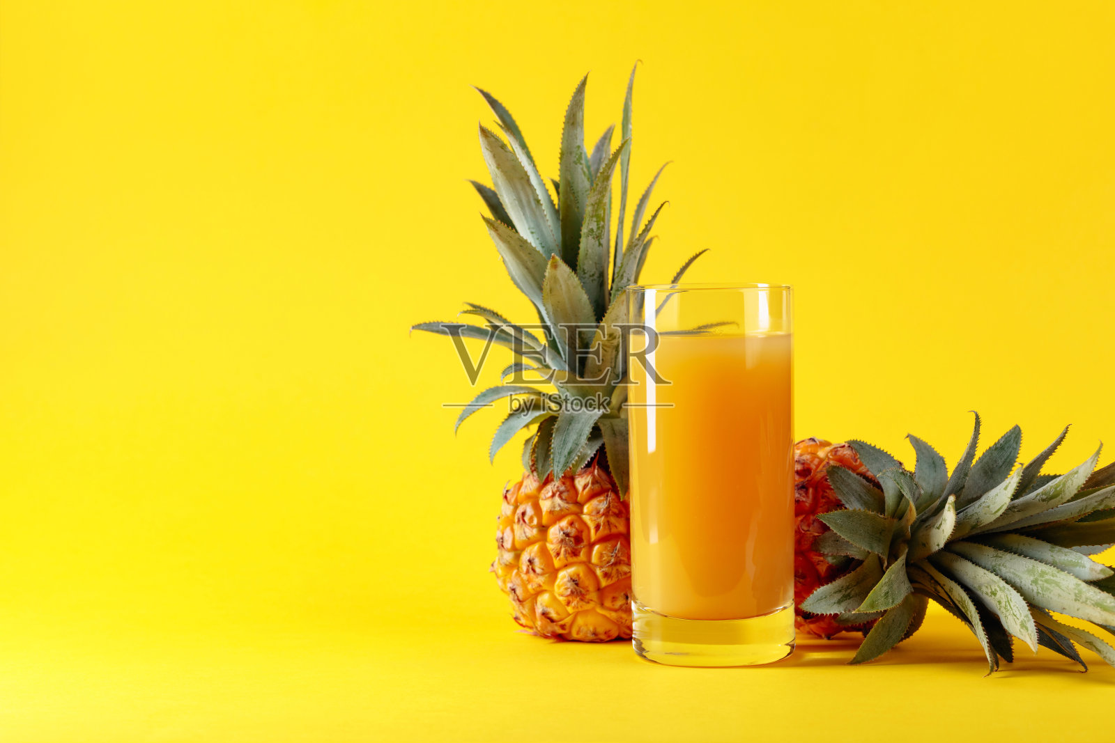 新鲜成熟的菠萝和果汁在黄色的背景。照片摄影图片