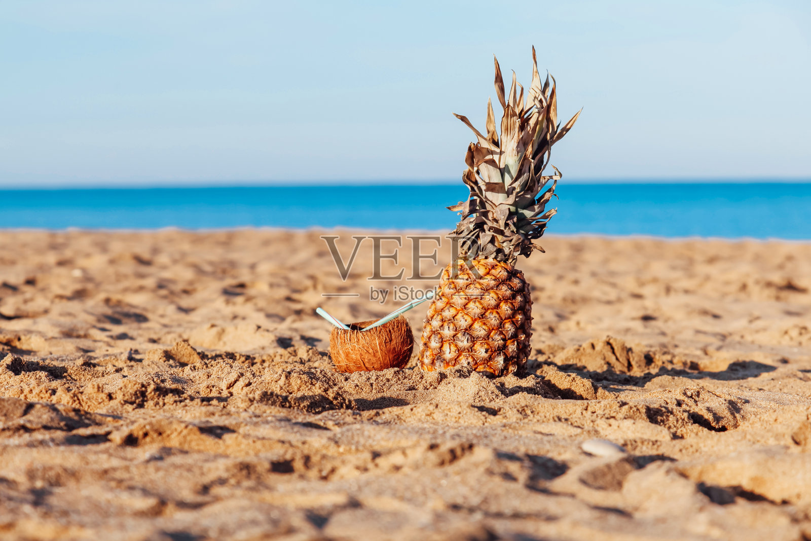 菠萝椰子鸡尾酒在沙滩上照片摄影图片